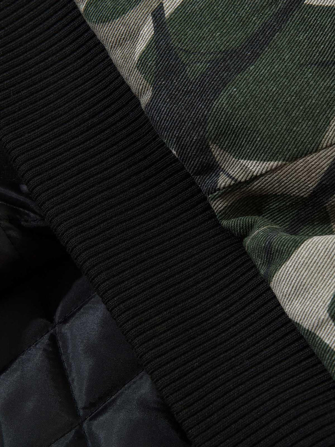 A detailed view of TALISHKO's bomber jacket, highlighting its quilted lining and camouflage fabric.