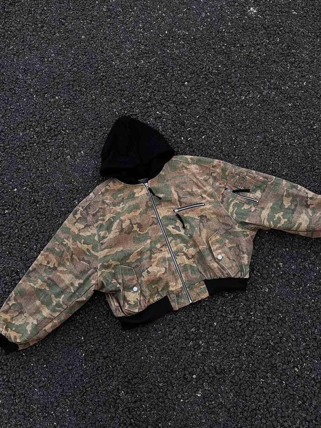 A laid-flat TALISHKO camouflage jacket with a faux two-piece hooded design on textured ground.