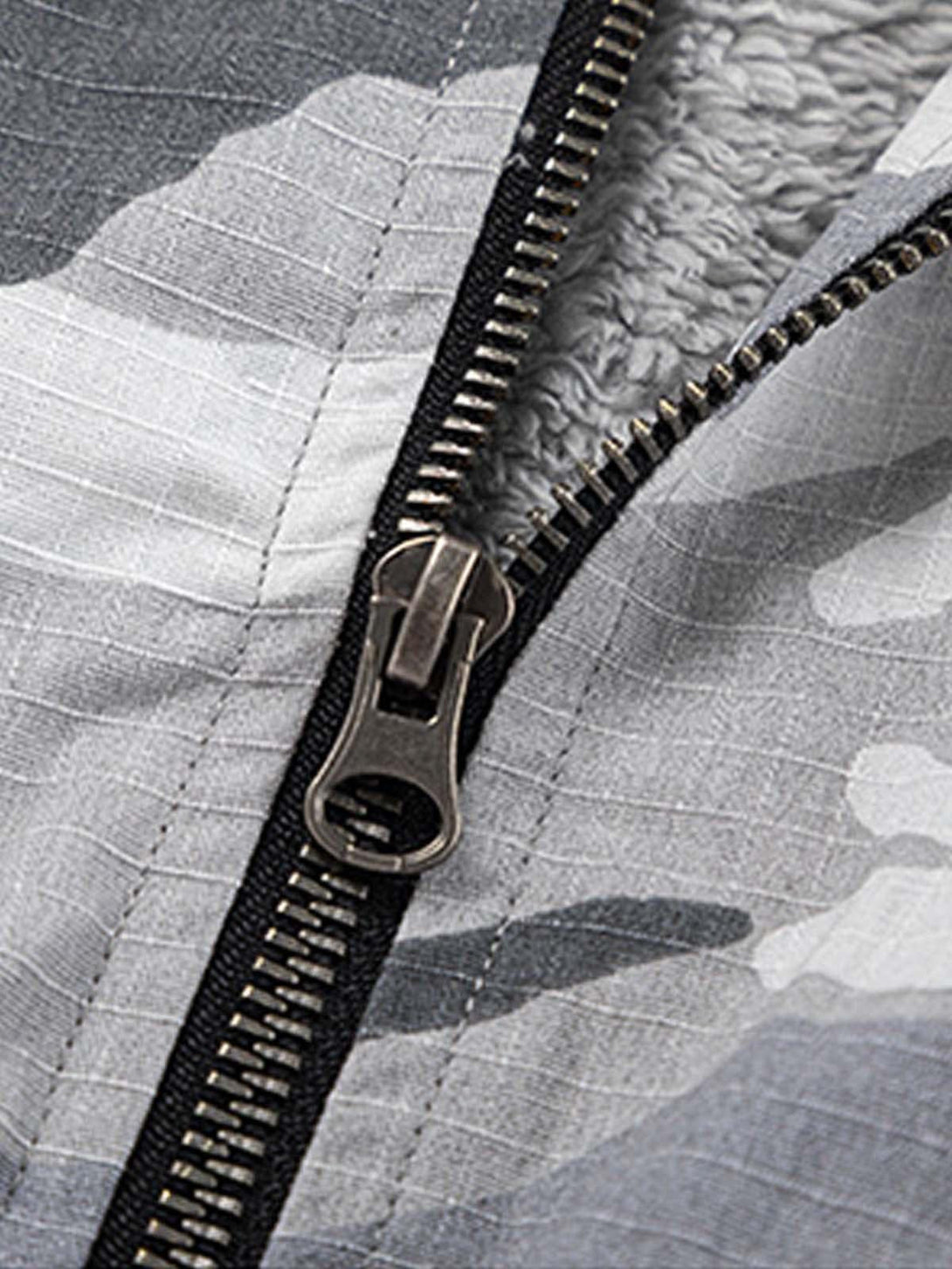 A close-up of the zipper on a camouflage fleece hooded jacket by TALISHKO, revealing cozy lining.