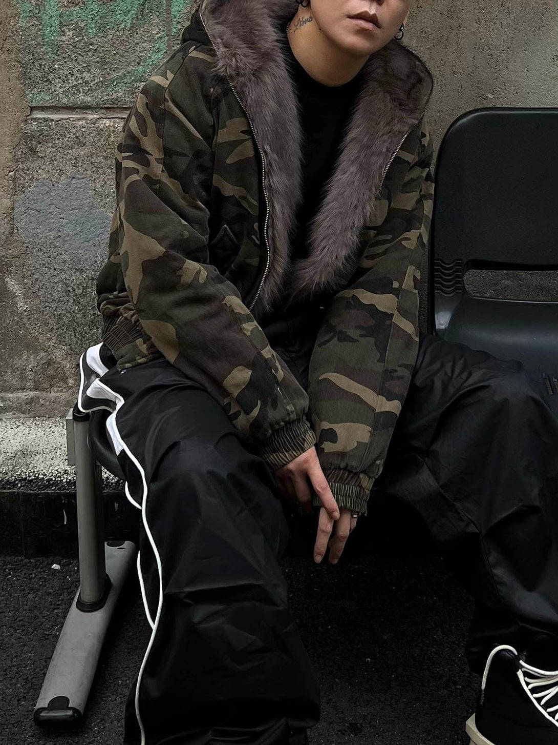 Model wearing a TALISHKO camouflage fur collar jacket, paired with black pants for a stylish urban look.