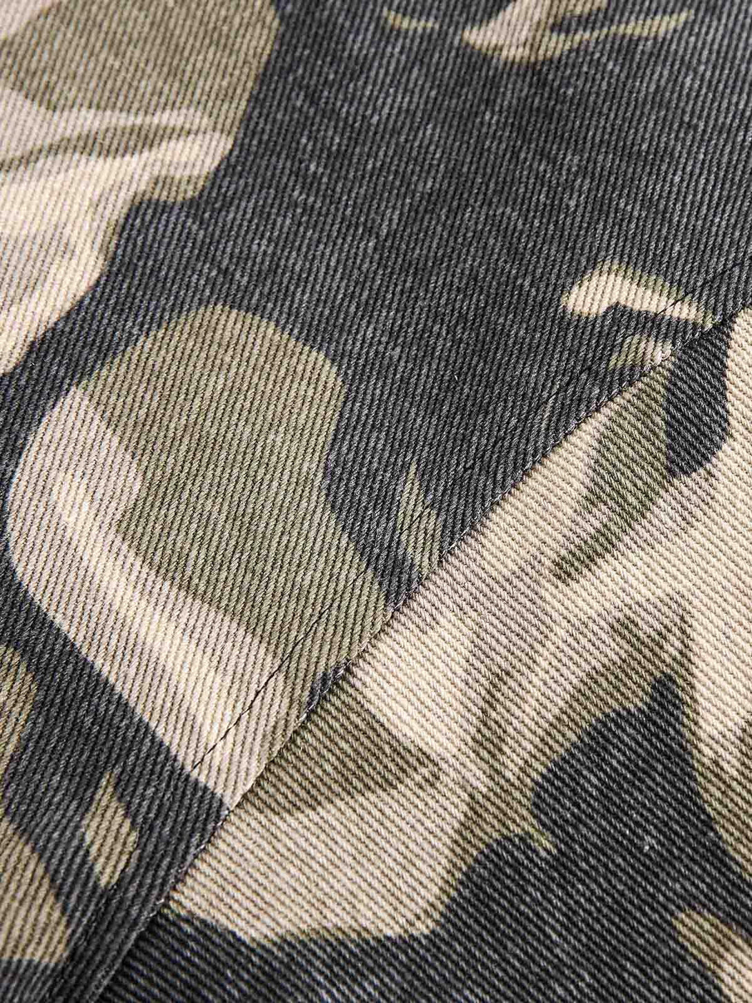 Zoomed-in texture of the TALISHKO camouflage jacket fabric, highlighting detailed stitching.