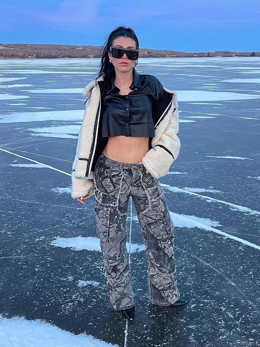 A model wears TALISHKO camouflage pants paired with a leather top and shearling jacket.