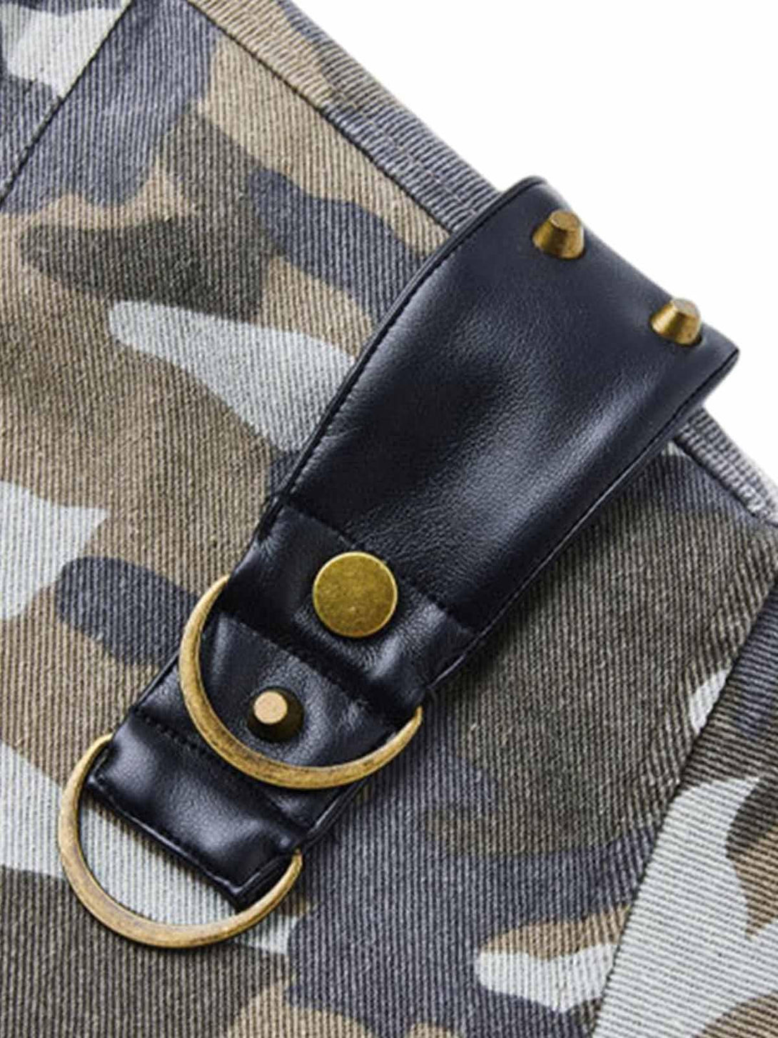 Focusing on the leather and brass detailing of a TALISHKO camouflage bomber jacket.