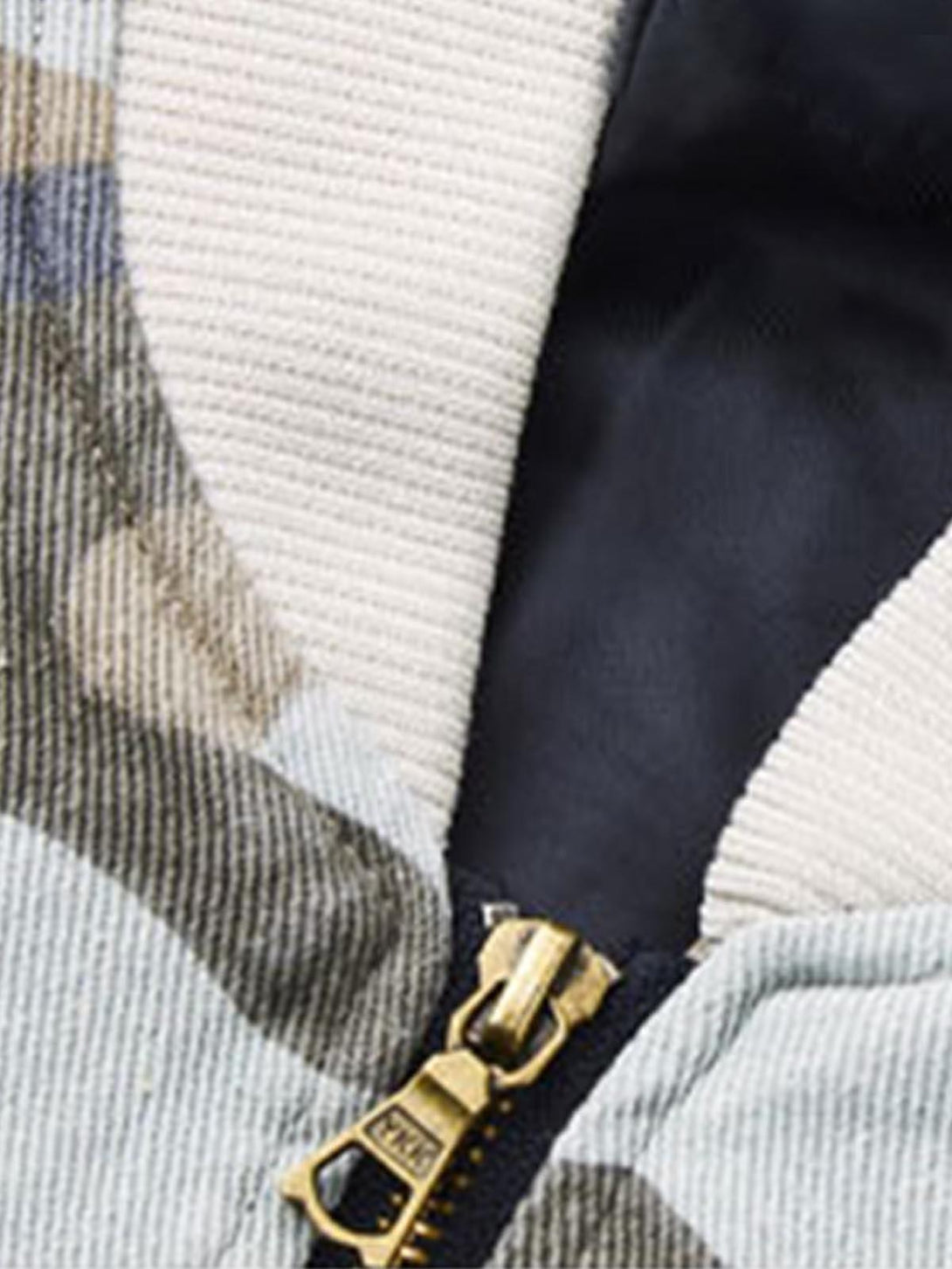 A detailed view of the zipper and fabric texture on a TALISHKO bomber jacket with leather accents.