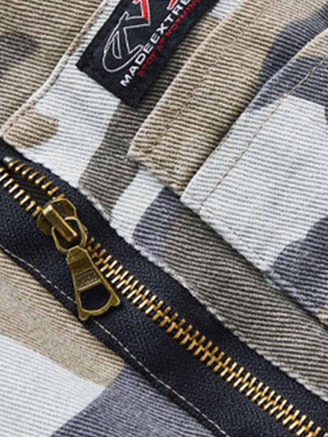 Intricate look at the zipper and fabric pattern on a TALISHKO camouflage denim bomber jacket.