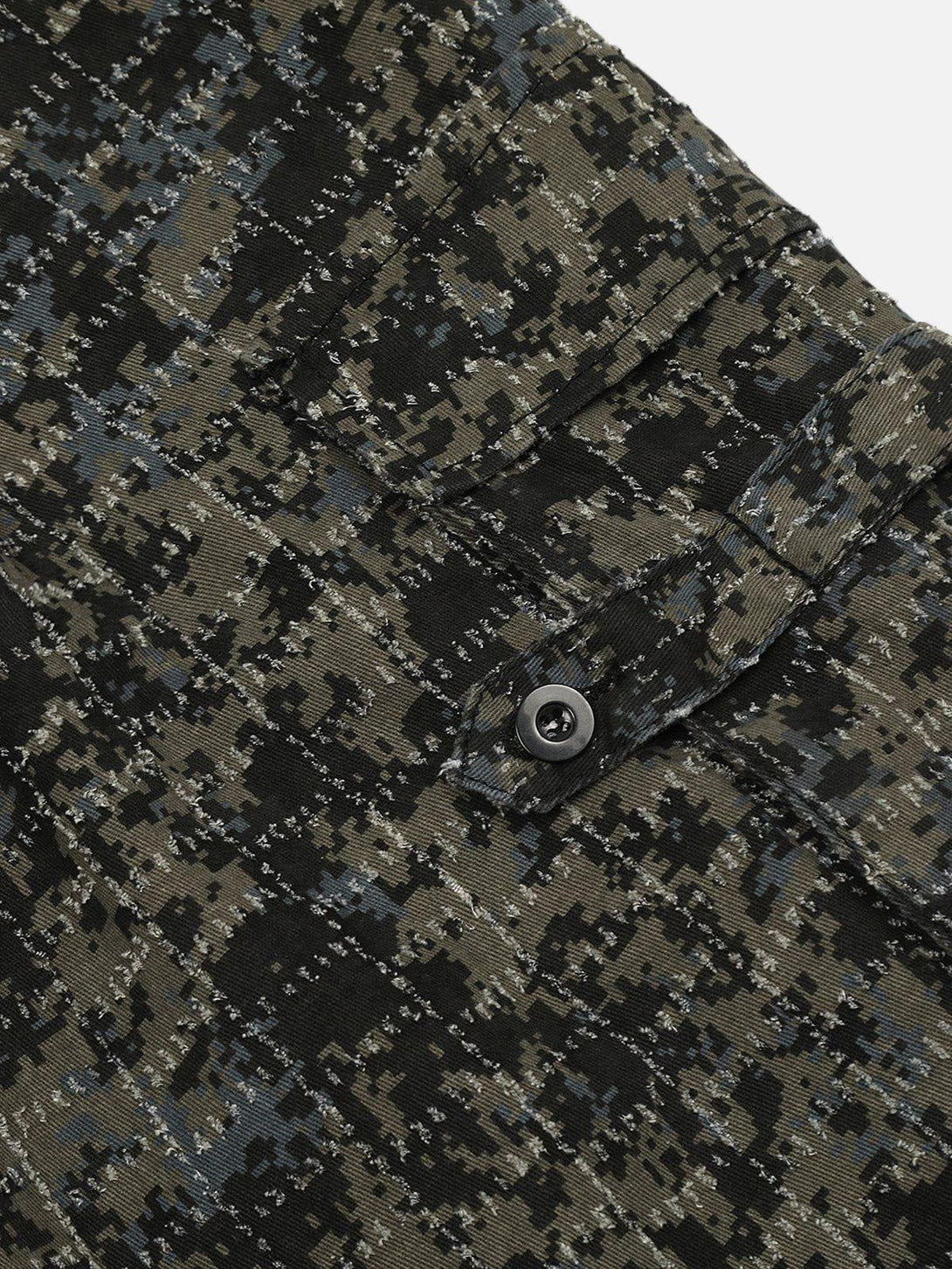A detailed look at TALISHKO's camouflage fabric and button detail on loose jeans.
