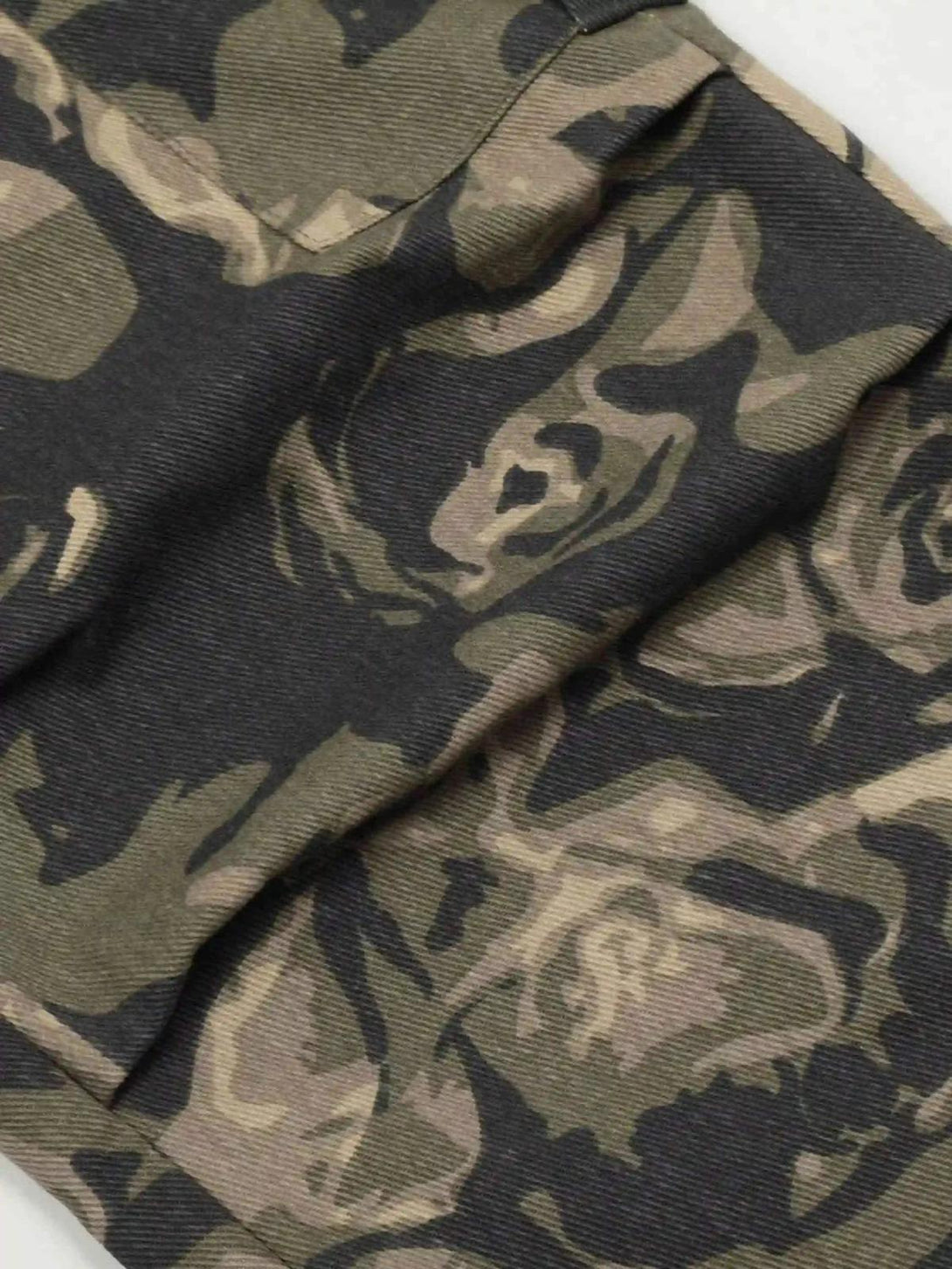 Zoomed-in texture of TALISHKO camouflage work pants, showcasing rugged fabric and pattern.
