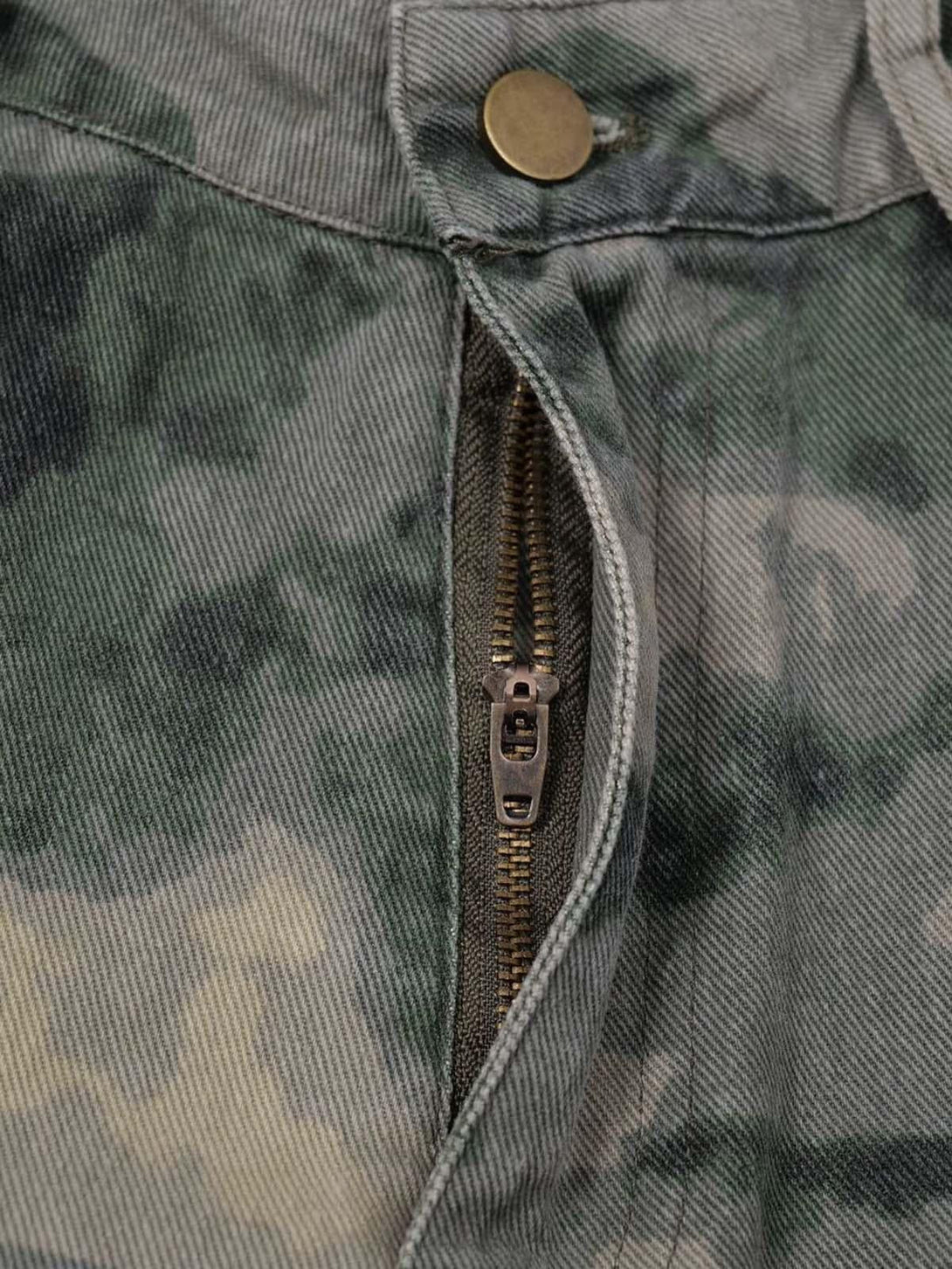 Close-up of TALISHKO cargo pants, highlighting the camouflage pattern and sturdy zipper detail.