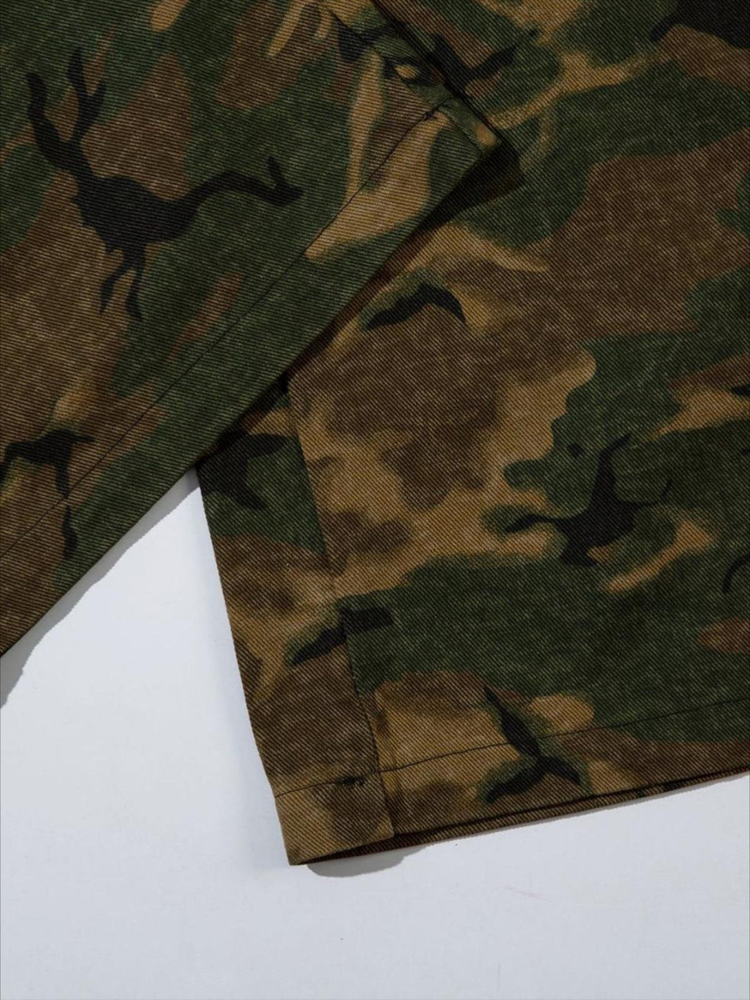 Detailed fabric and stitching of TALISHKO's camouflage oversize denim cargo pants.