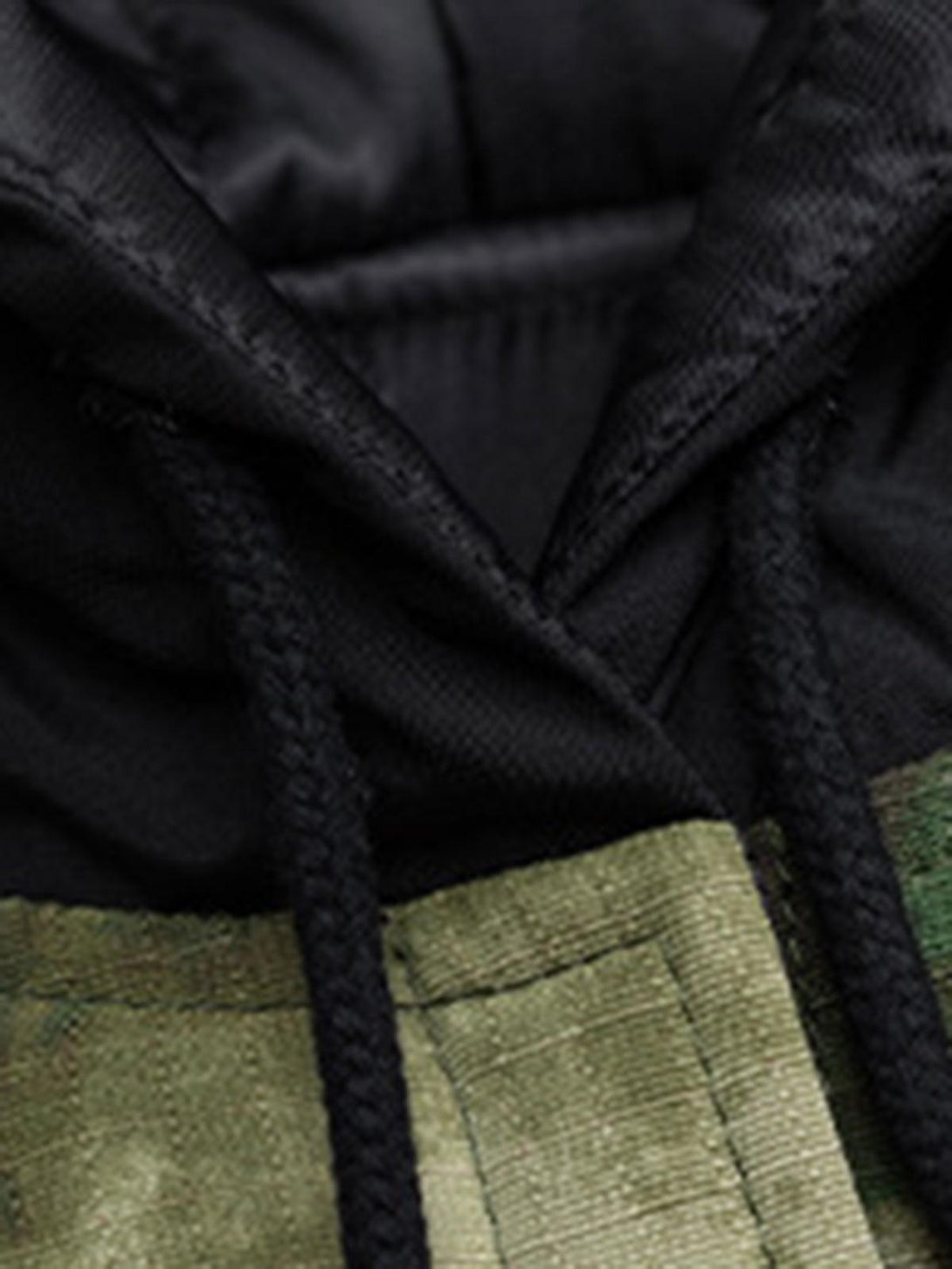 Zoomed-in texture of TALISHKO's camouflage hooded jacket, highlighting black hood details.