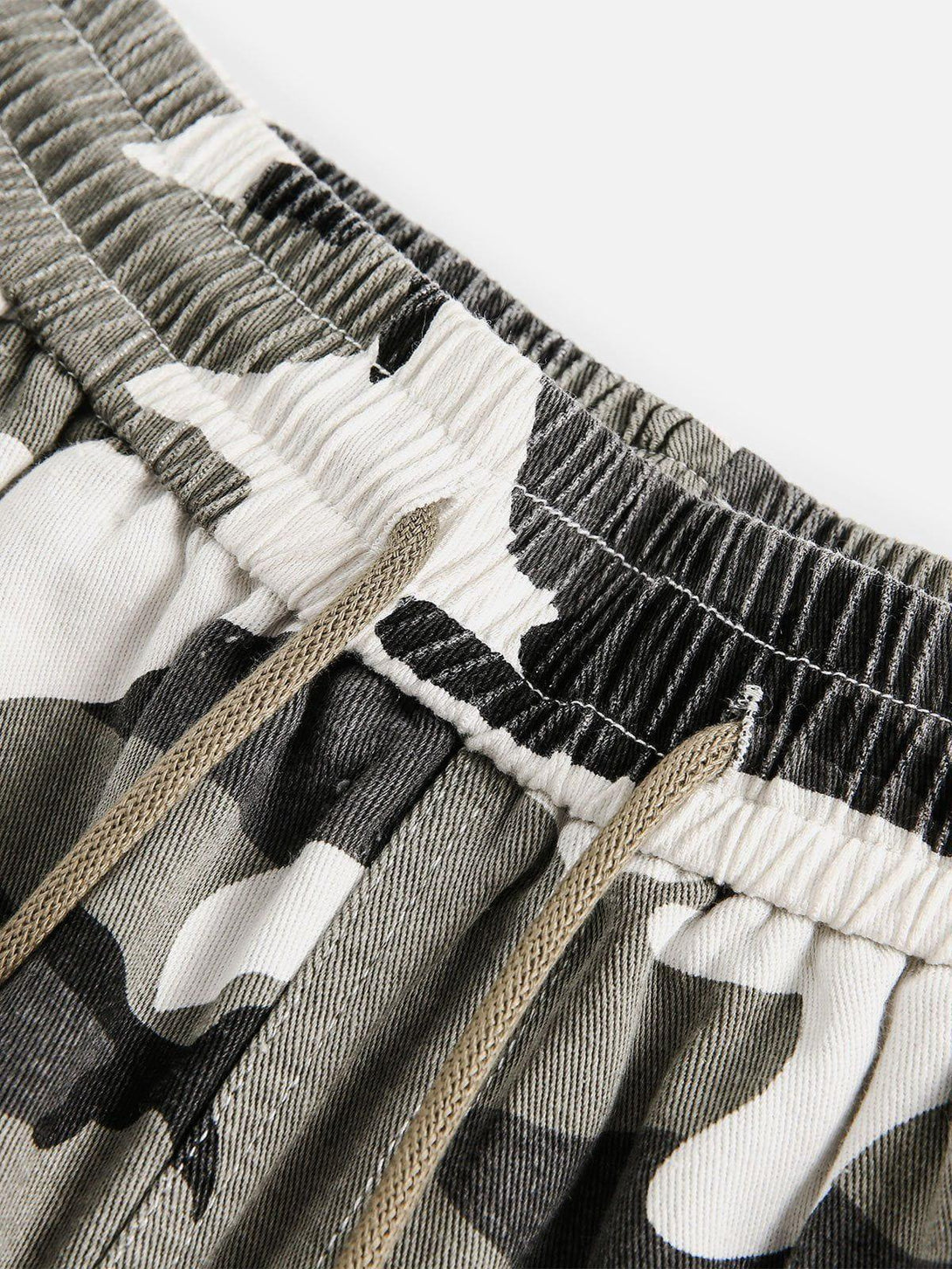 Elastic waist detail in TALISHKO camouflage patchwork shorts, highlighting texture and style.