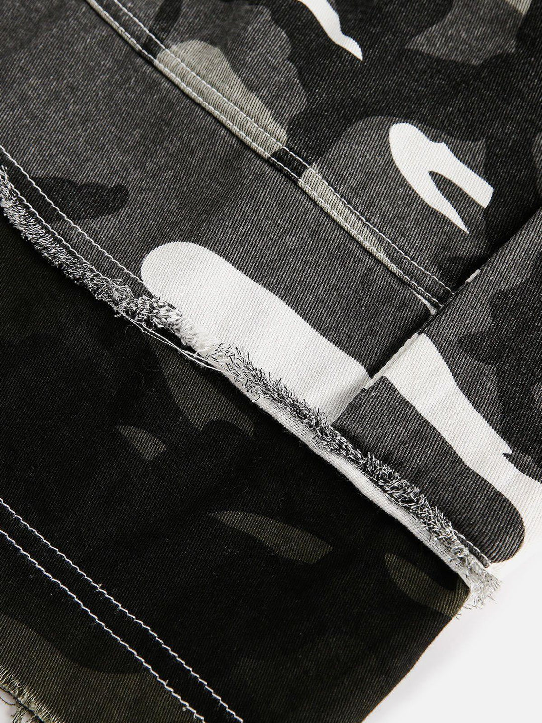 Frayed hem detail of TALISHKO camouflage patchwork shorts, highlighting unique texture.