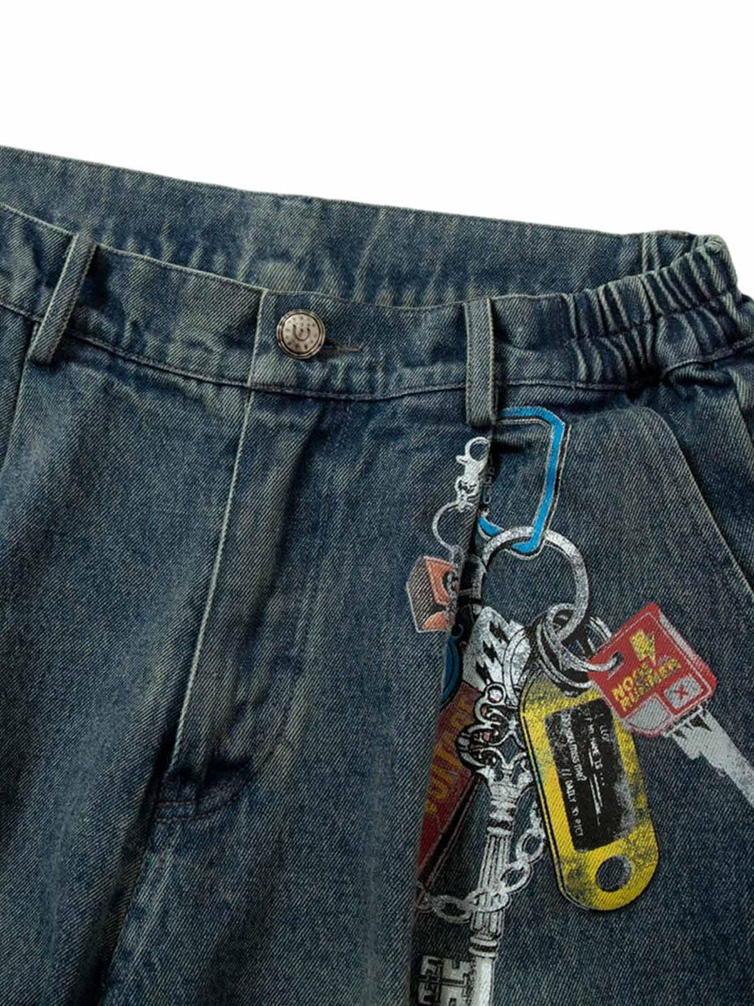 Detailed view of TALISHKO jeans with unique keychain print and stylish pleated waistband.