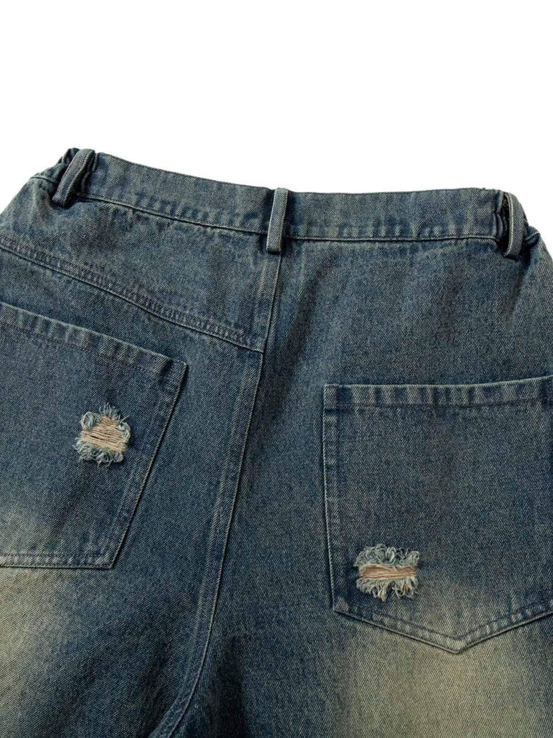 Back view of TALISHKO jeans highlighting distressed pockets and rugged denim texture.