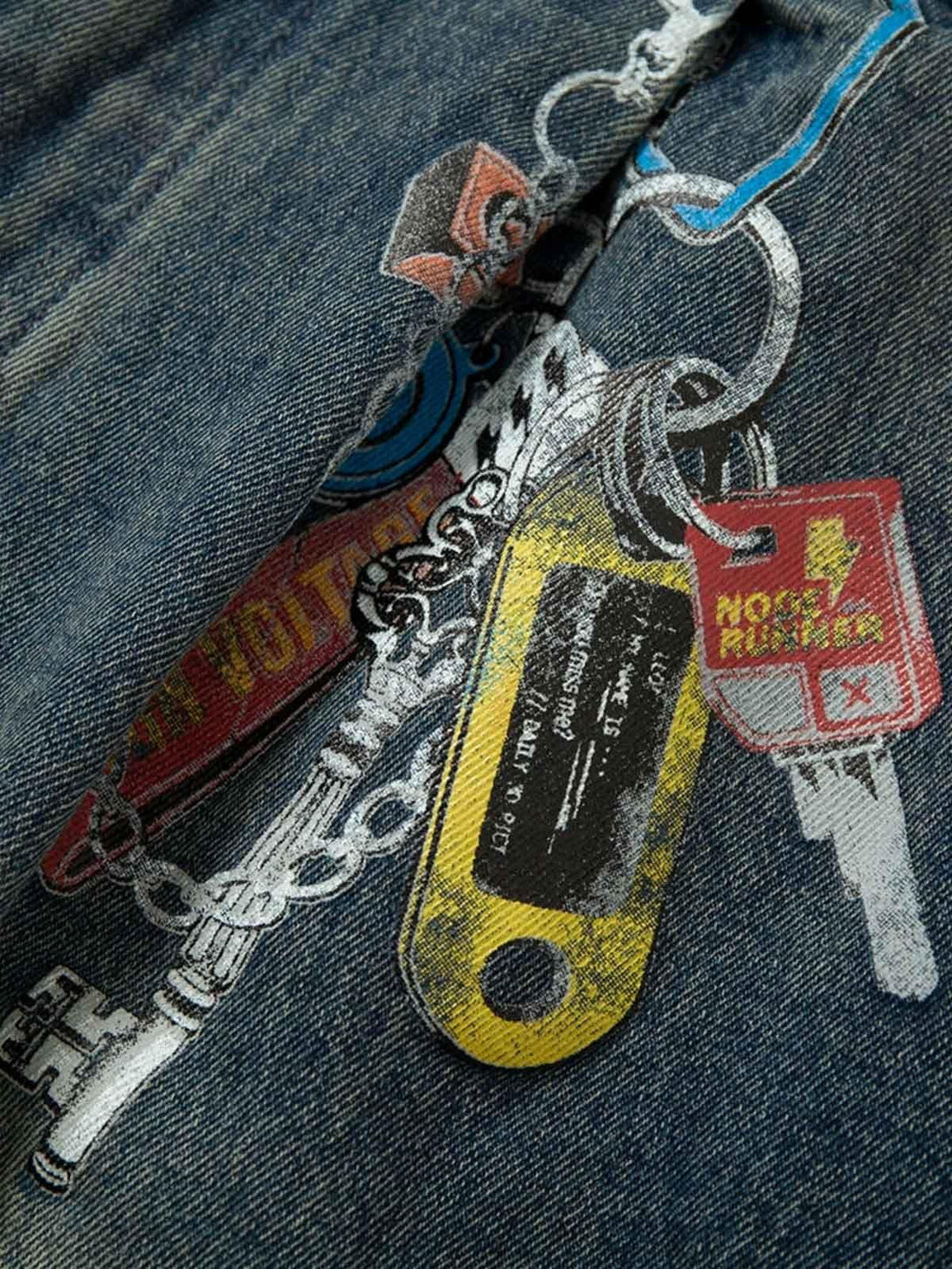 Intricate look at TALISHKO jeans showcasing a unique keychain graphic on denim fabric.