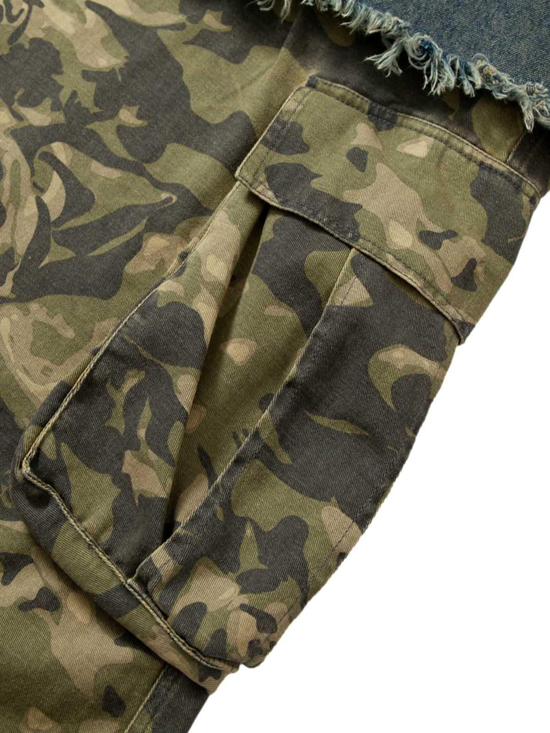 Intricate look at TALISHKO jeans featuring camouflage patch pocket and frayed denim edge.