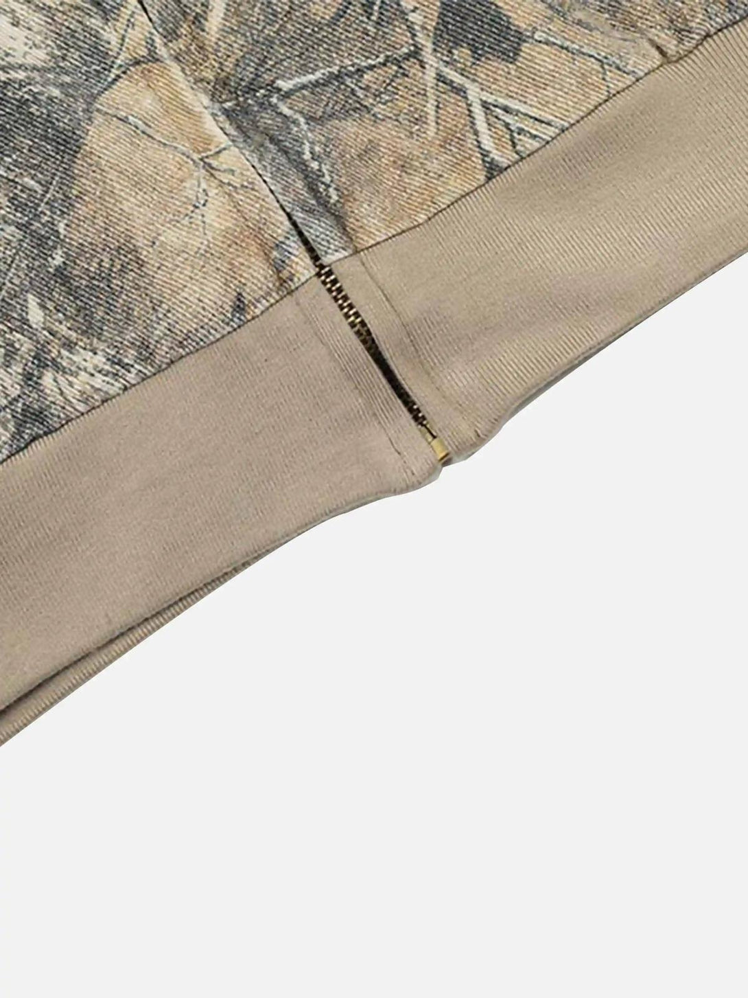 A detailed view of the hem and camouflage pattern on a TALISHKO zip-up hoodie, highlighting texture.