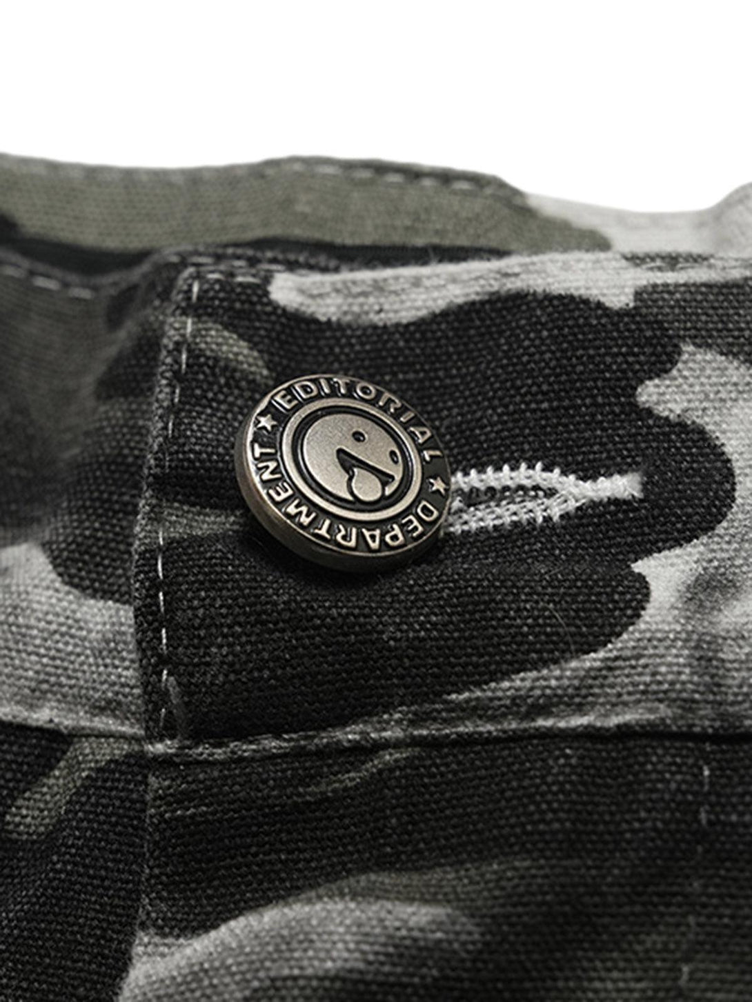 A close-up of TALISHKO's camouflage cargo pants button, highlighting detailed fabric and stitching.