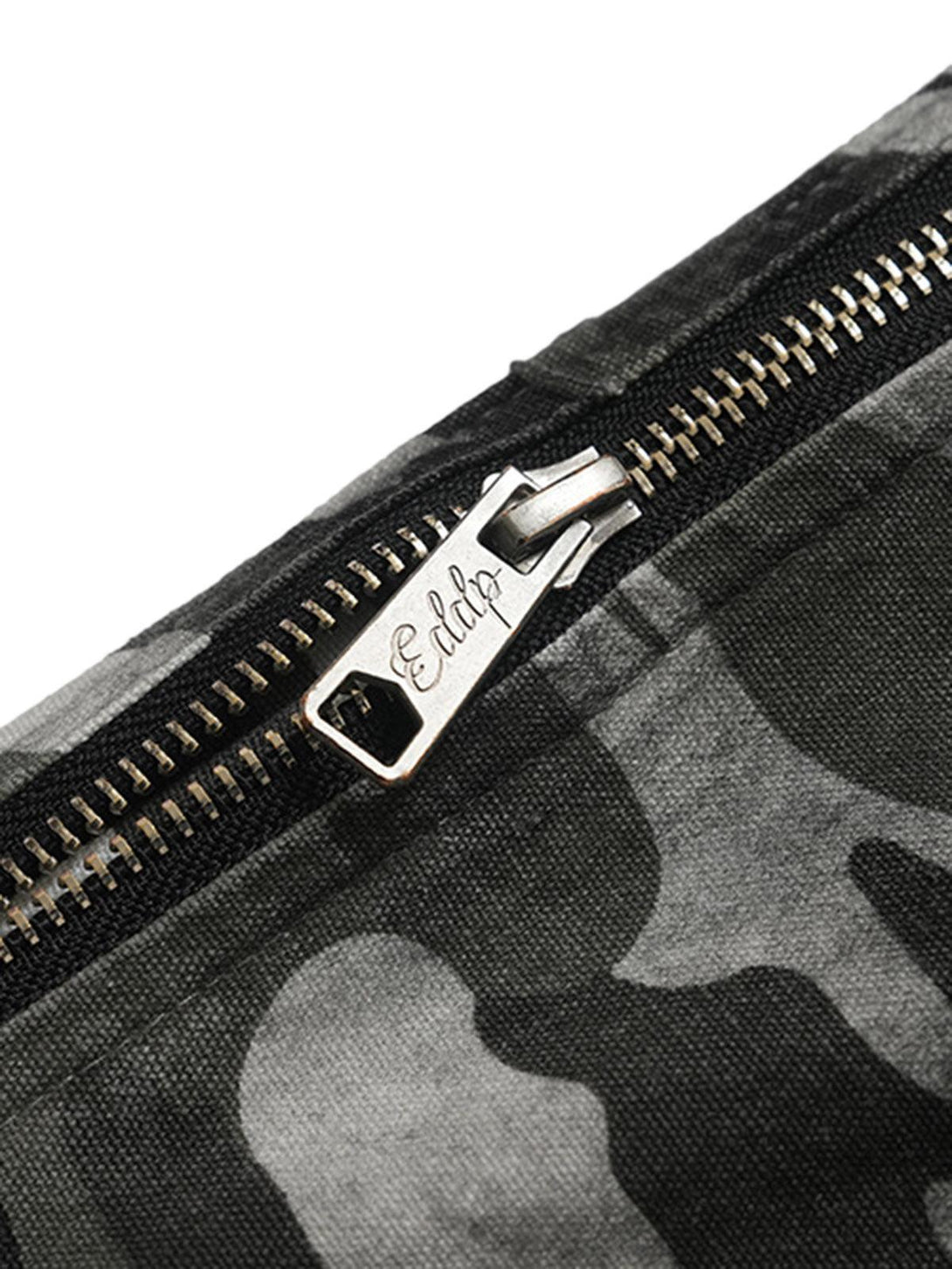 A detailed view of the zipper on TALISHKO's retro camouflage cargo pants, showcasing craftsmanship.