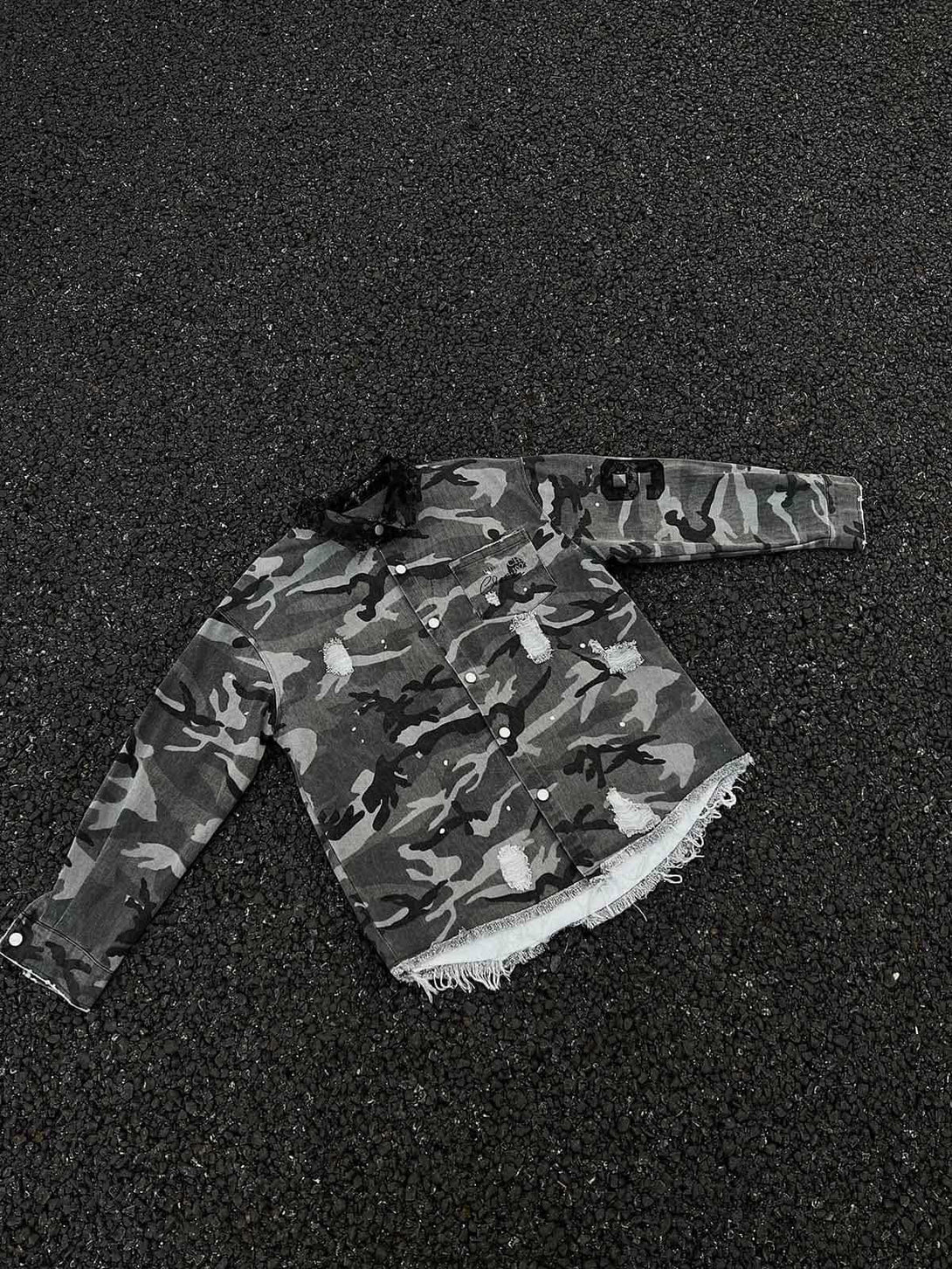 A rugged camouflage denim shirt by TALISHKO, featuring ripped details and lace trim.