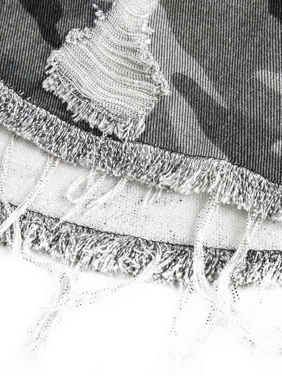 Texture and pattern showcased in TALISHKO's camouflage denim shirt, highlighting frayed edges.