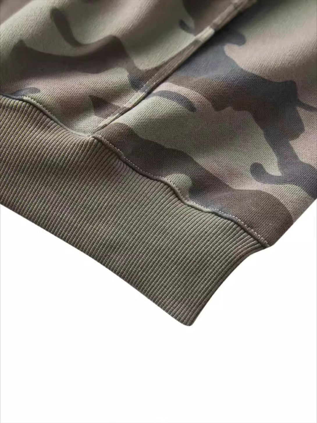 A close-up of a TALISHKO camouflage zipper hoodie's ribbed hem, highlighting detailed texture.