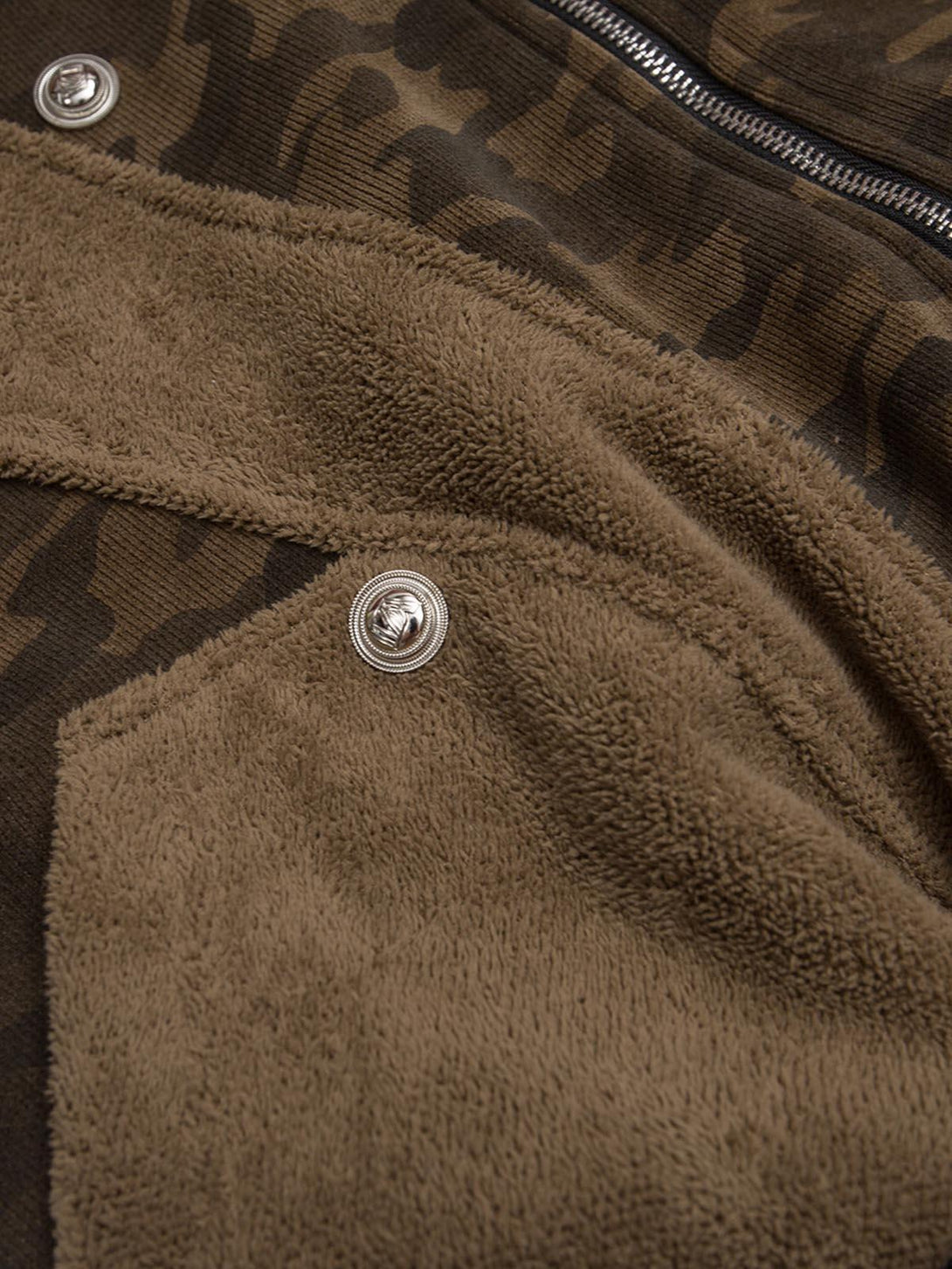 Detailed fabric and button design on TALISHKO's camouflage fleece jacket, highlighting texture.
