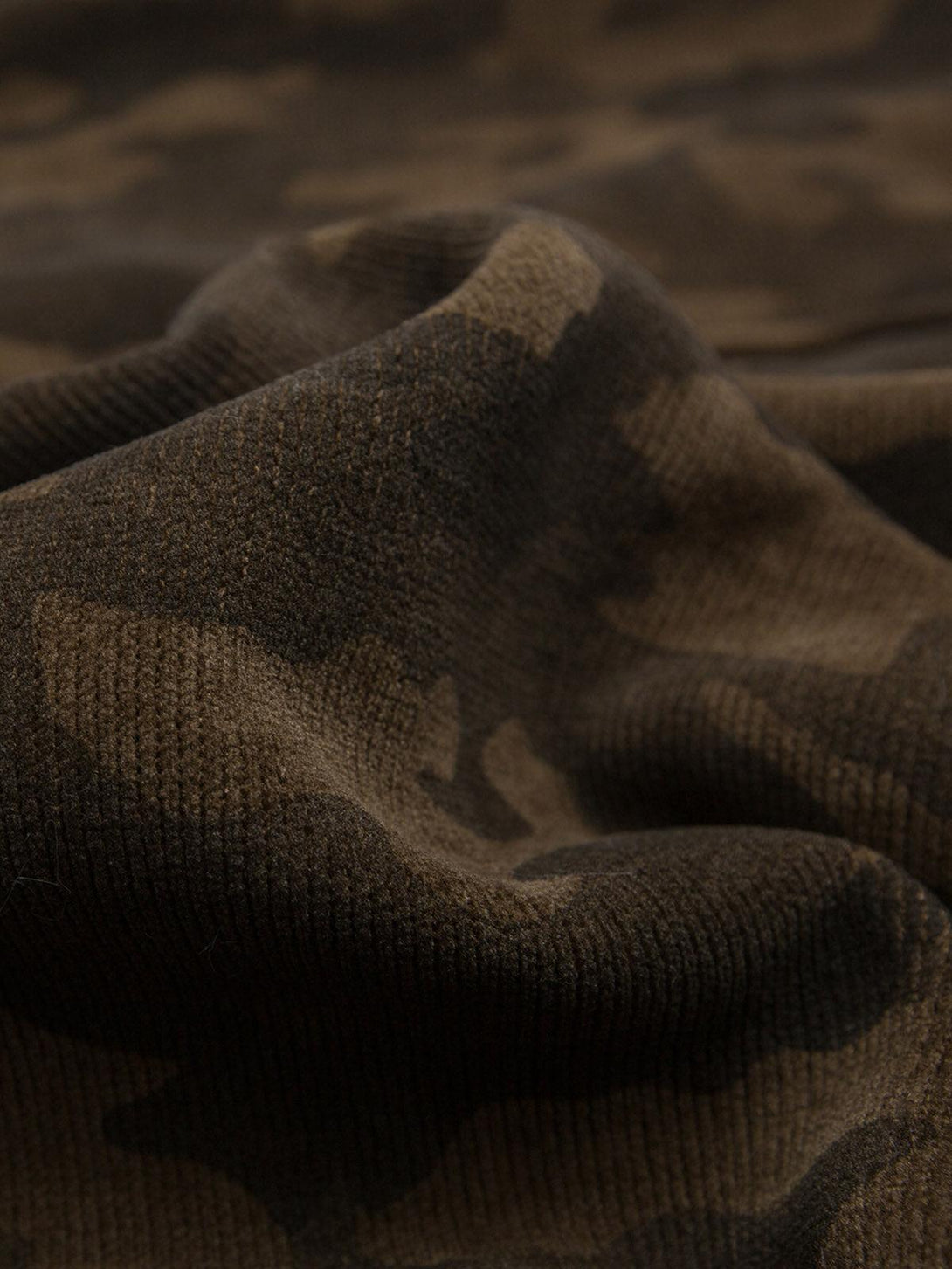 A detailed view of TALISHKO's camouflage fleece fabric, showcasing its rich texture and pattern.
