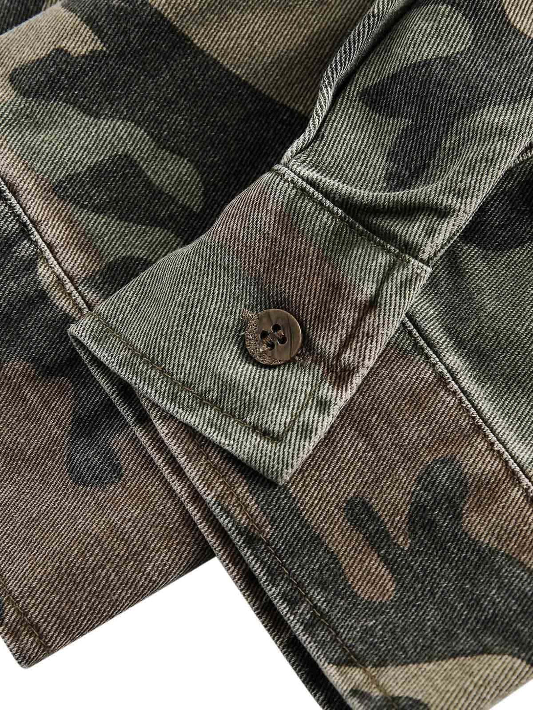 Detailed fabric and button of TALISHKO's distressed camouflage denim shirt, showcasing rugged style.