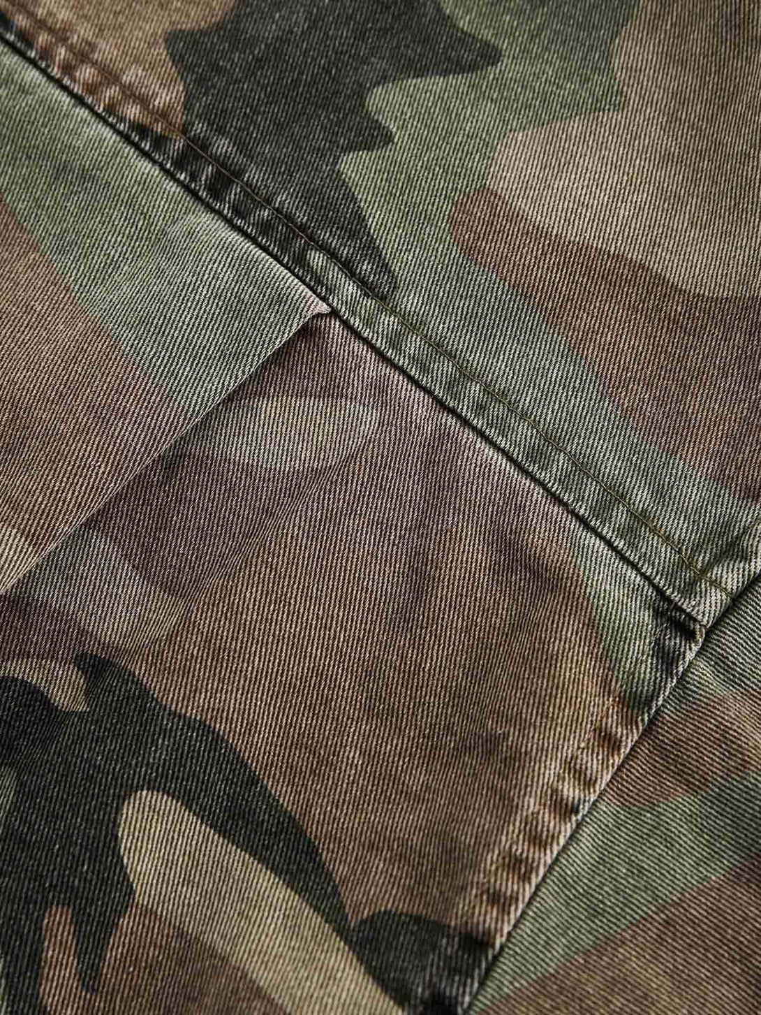 Intricate look at the camouflage pattern and stitching on TALISHKO's distressed denim shirt.