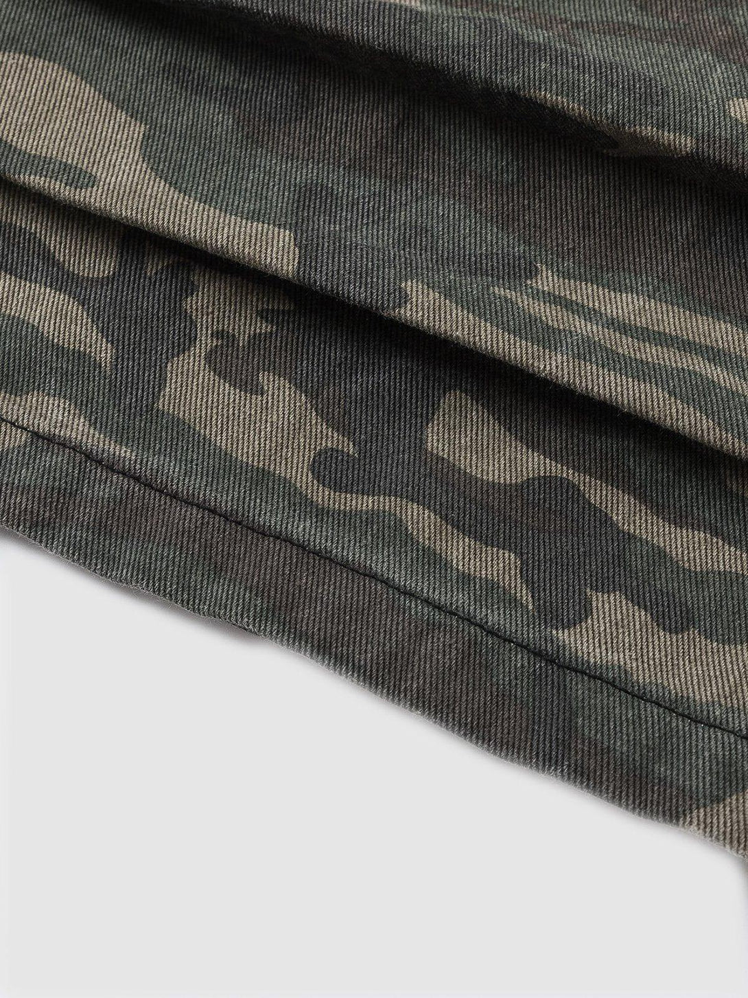 Zoomed-in texture of TALISHKO's camouflage fabric, highlighting intricate patterns and rugged style.