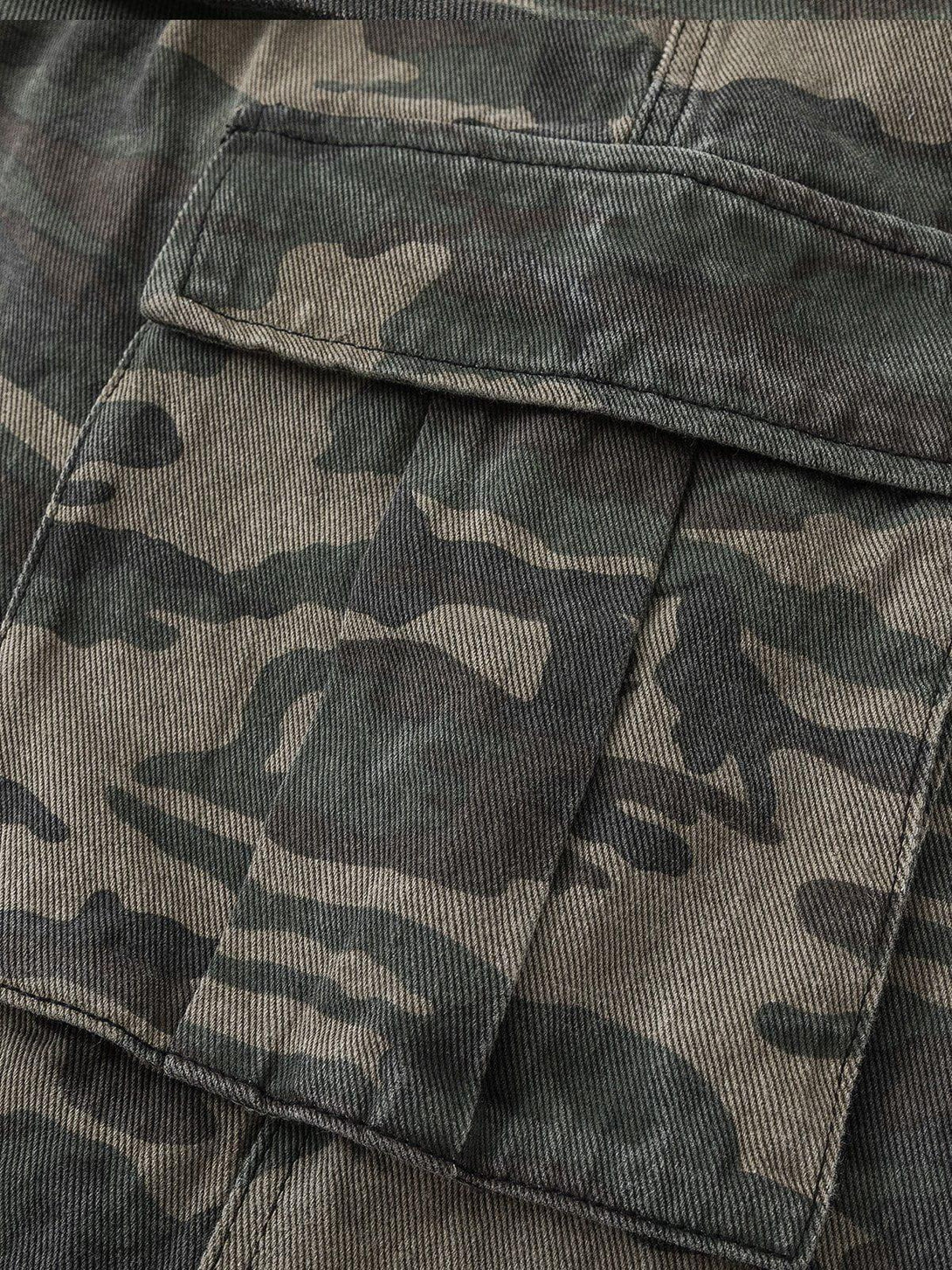 Detailed fabric and stitching of TALISHKO's camouflage longline jorts, showcasing rugged texture.
