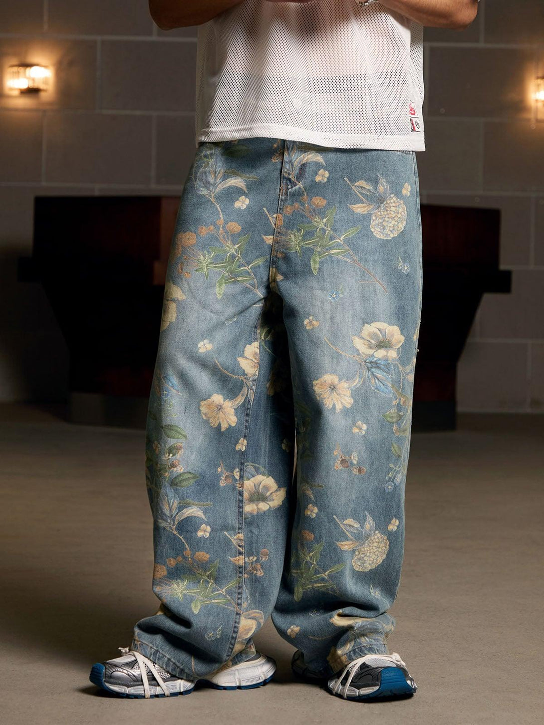 Relaxed-fit floral carpenter pants by TALISHKO, styled with a casual mesh top and sneakers.