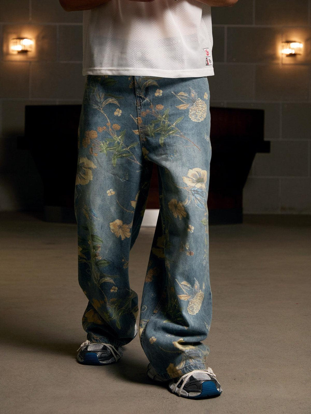 Relaxed-fit floral carpenter pants by TALISHKO, paired with sneakers and a mesh top.