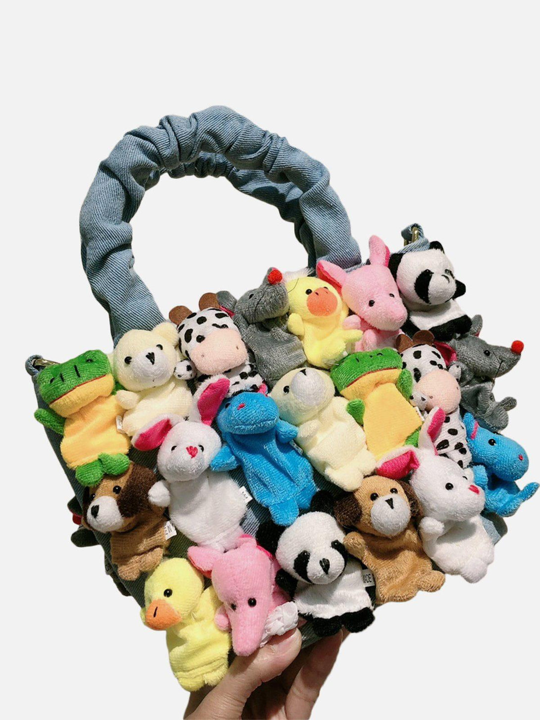TALISHKO's quirky bag features colorful plush animal dolls on a denim handle, adding charm.