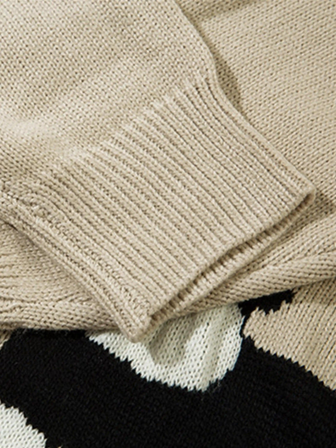 A tight crop highlighting the ribbed cuff detail on a knitted cardigan by TALISHKO.