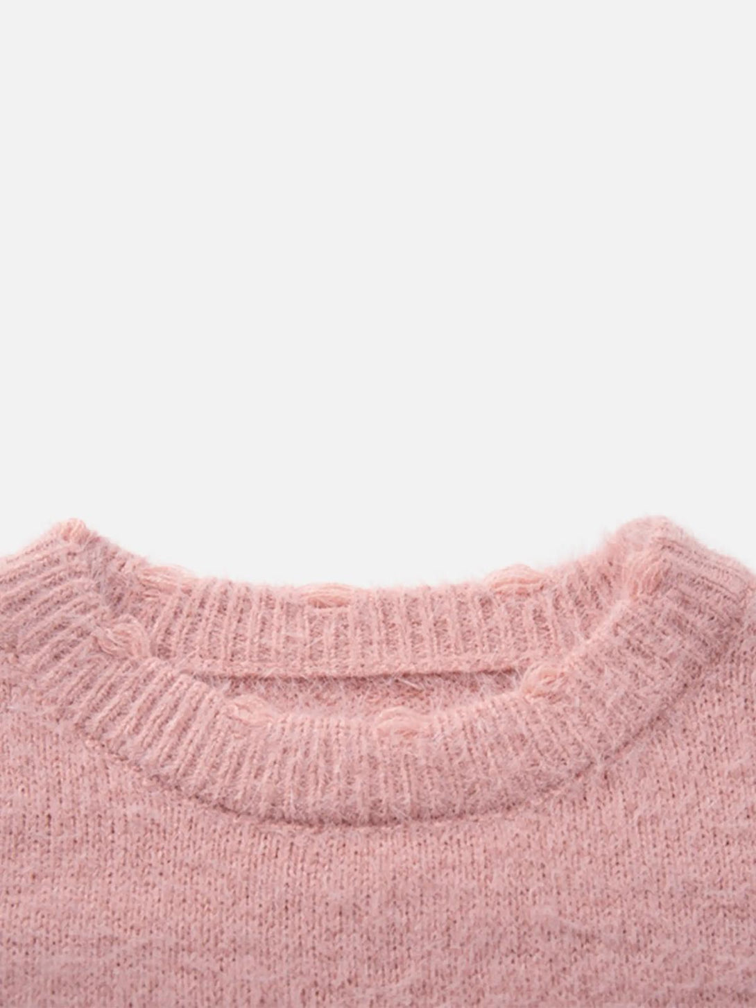 A detailed view of the soft, fluffy knit texture on TALISHKO's pink sweater.