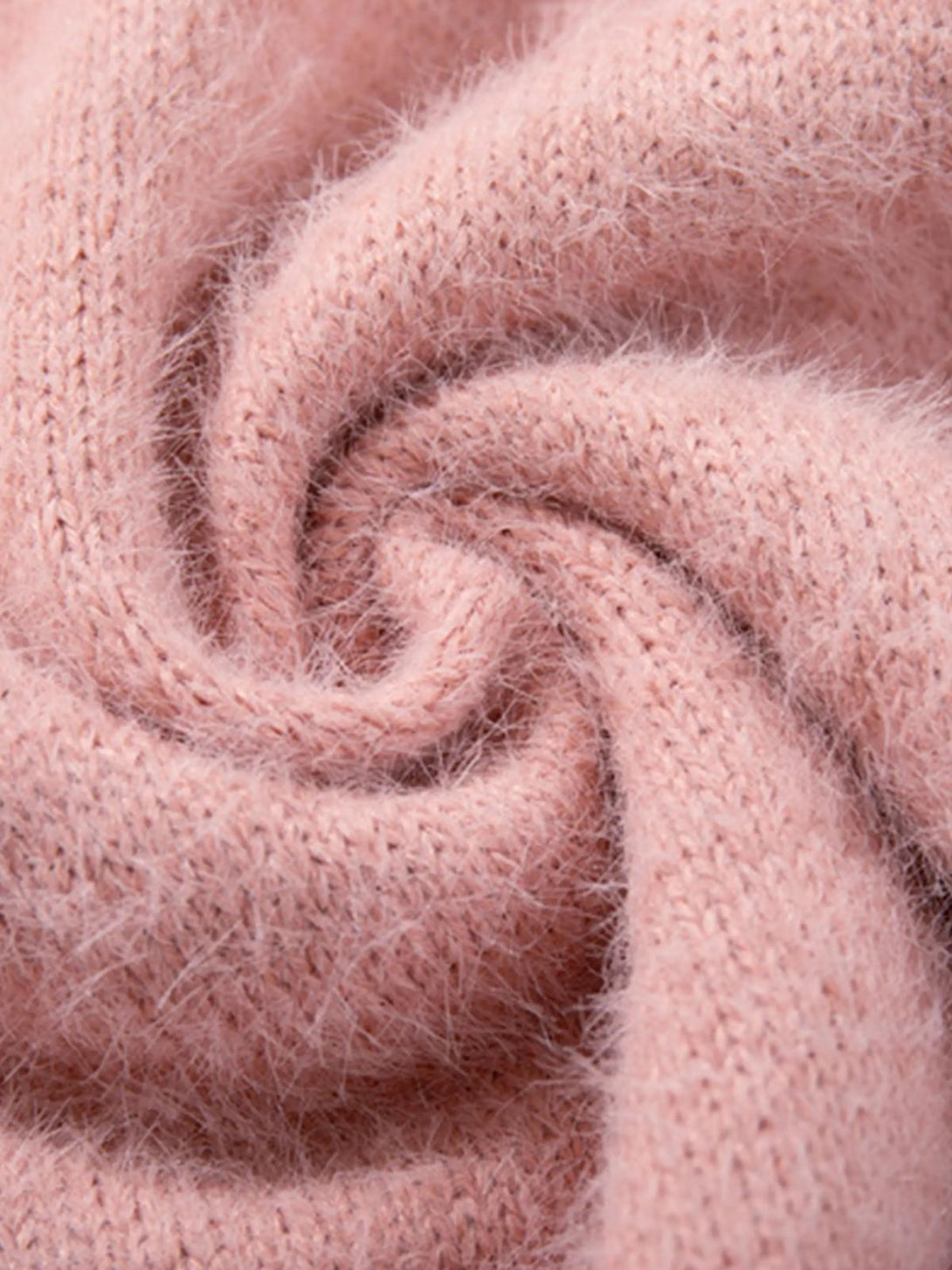 Intricate look at TALISHKO's pink sweater, emphasizing its soft, fluffy knit texture.