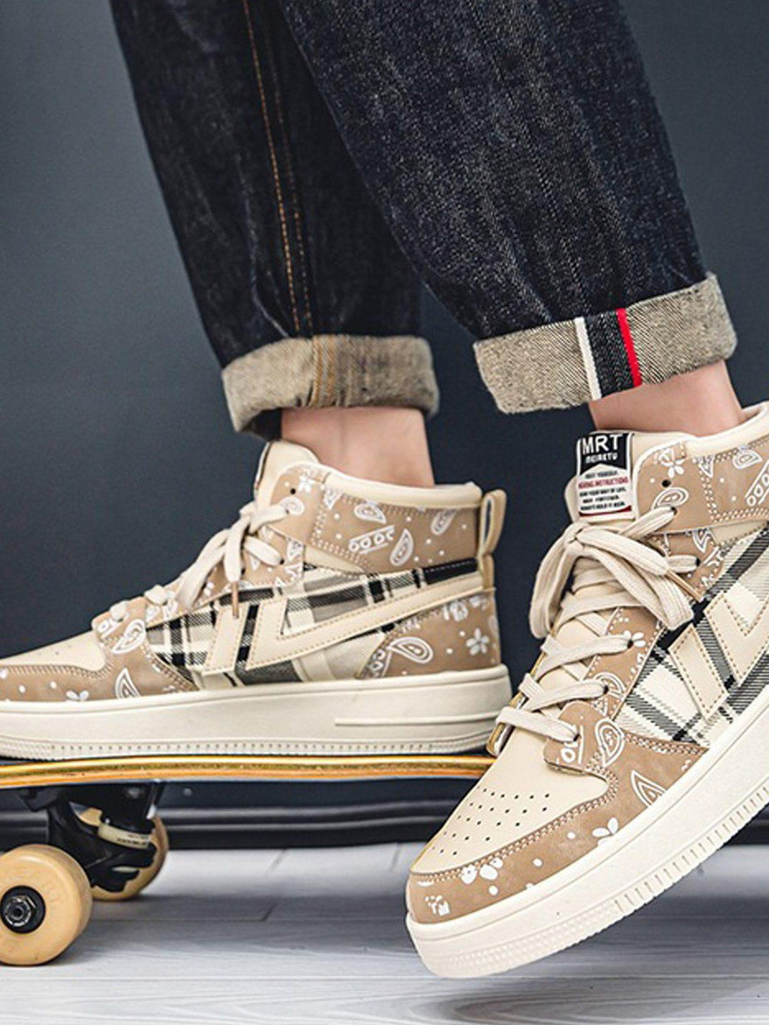 TALISHKO high-top platform sneakers in beige with paisley and plaid details, worn casually.