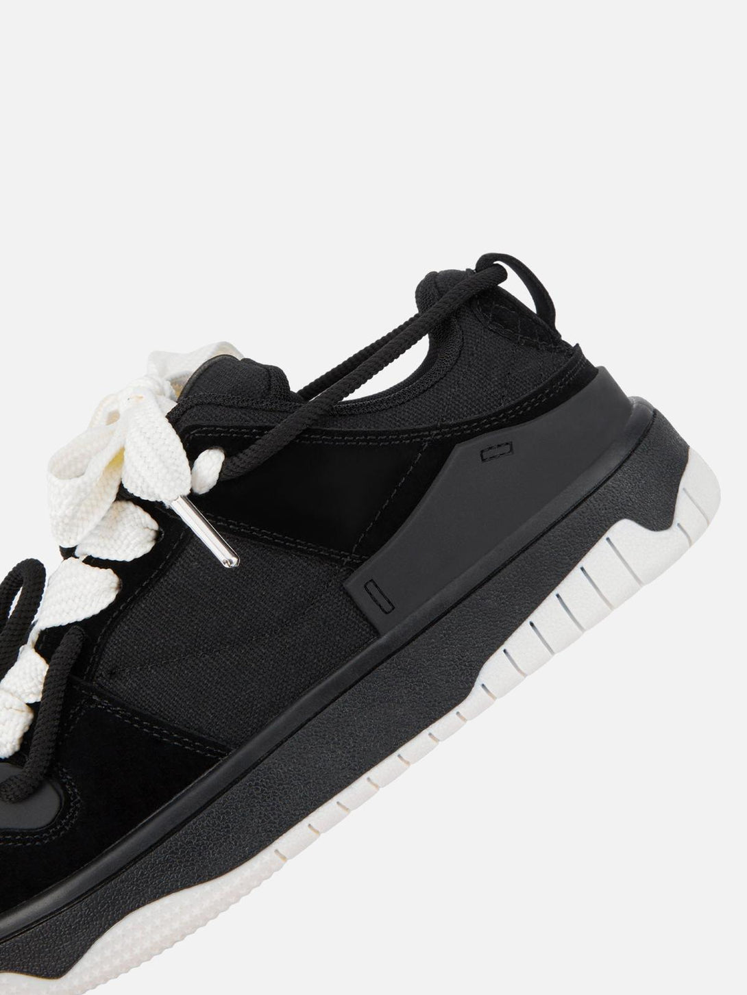 Detailed view of TALISHKO sports shoe, highlighting black upper with contrasting white sole.