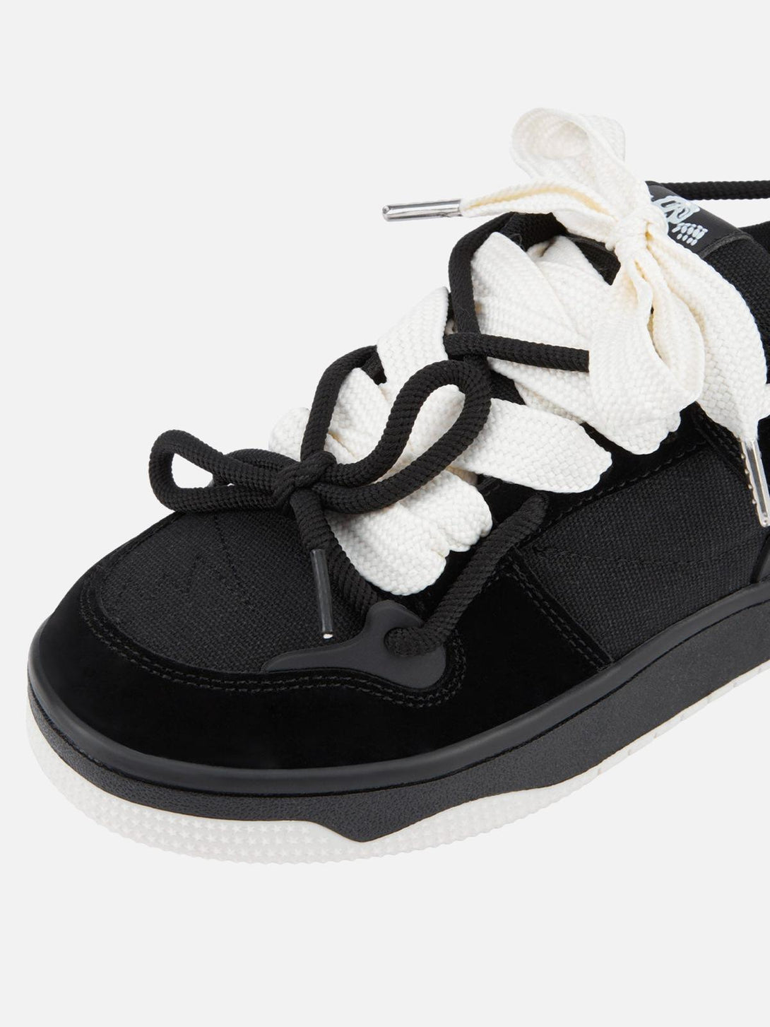 Intricate look at TALISHKO sports shoes, highlighting black and white laces for a stylish contrast.