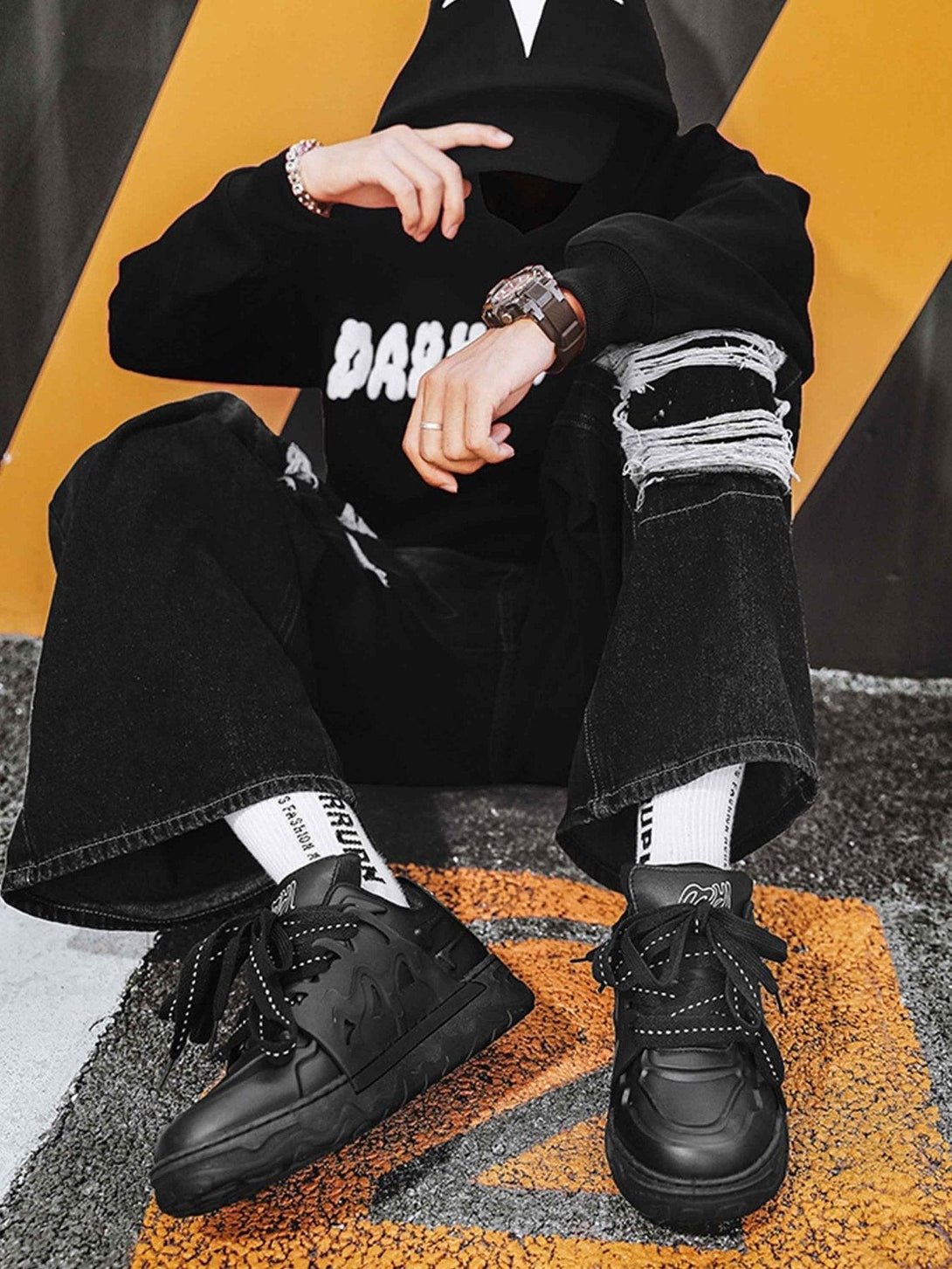 TALISHKO casual plate shoes in black, modeled with ripped jeans, capturing an edgy street vibe.