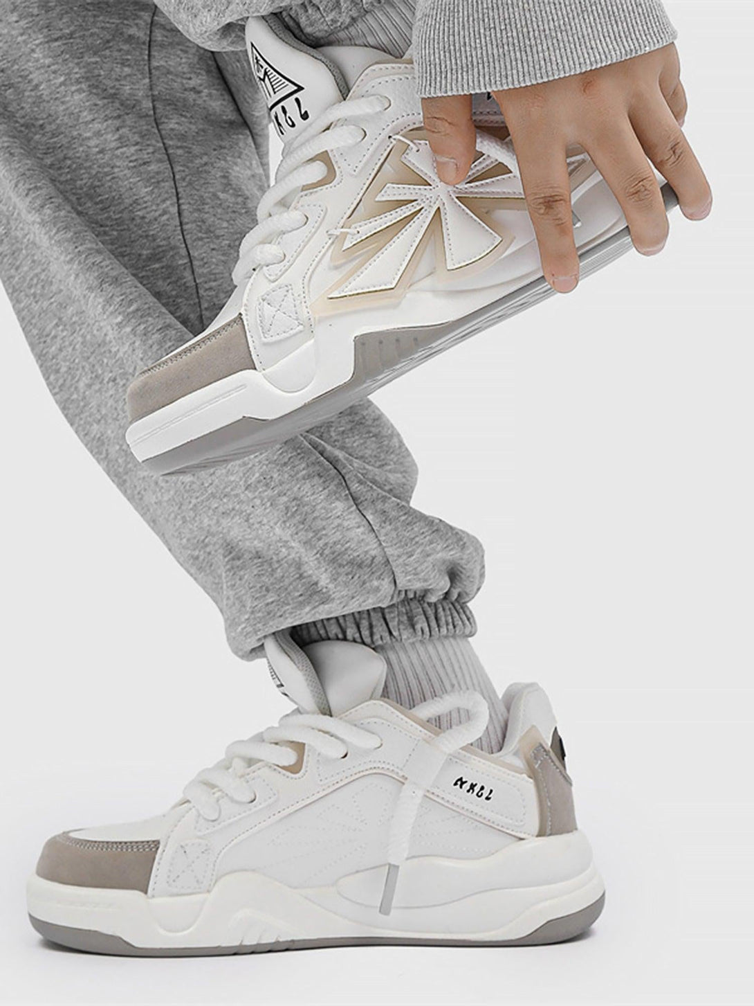 TALISHKO casual preppy sneakers in white, paired with gray joggers, showcasing sporty style.