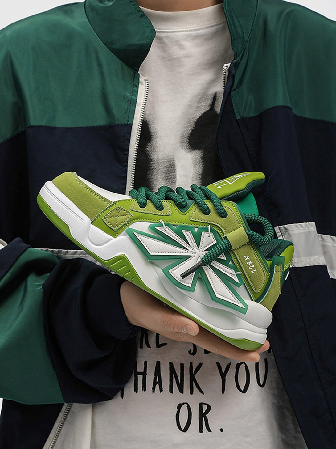 Holding green casual preppy sneakers by TALISHKO, highlighting bold design elements.