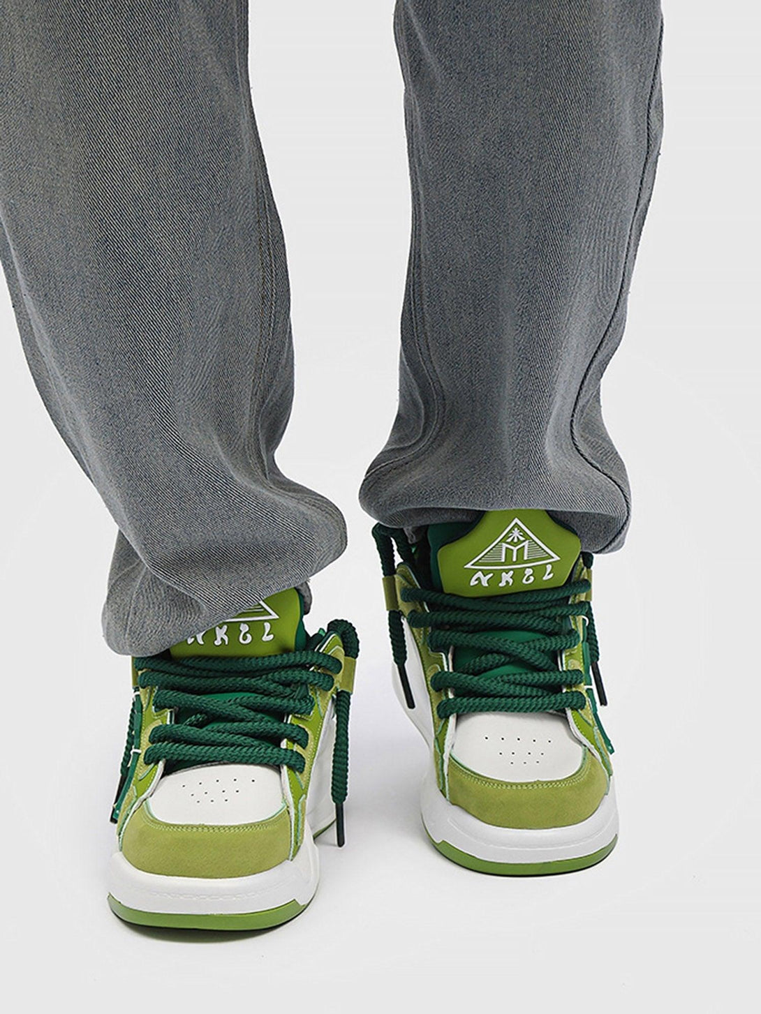 TALISHKO green preppy sneakers paired with gray jeans for a fresh, casual look.