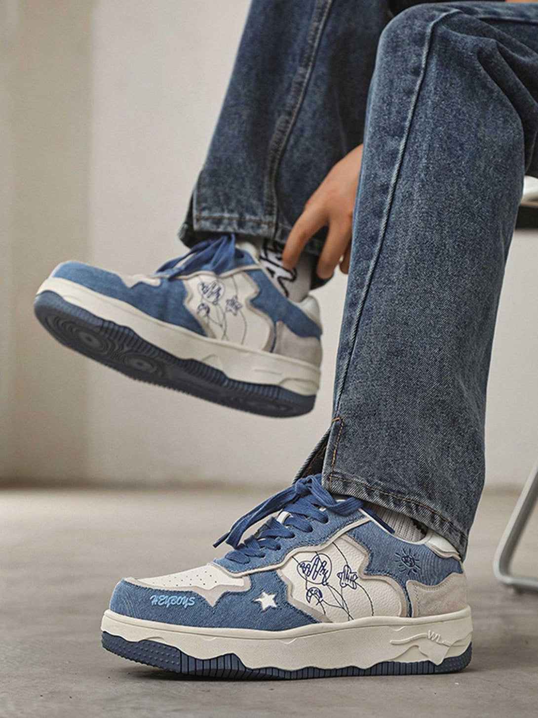 Casual blue sneakers by TALISHKO with unique stitching, paired with jeans for a laid-back style.