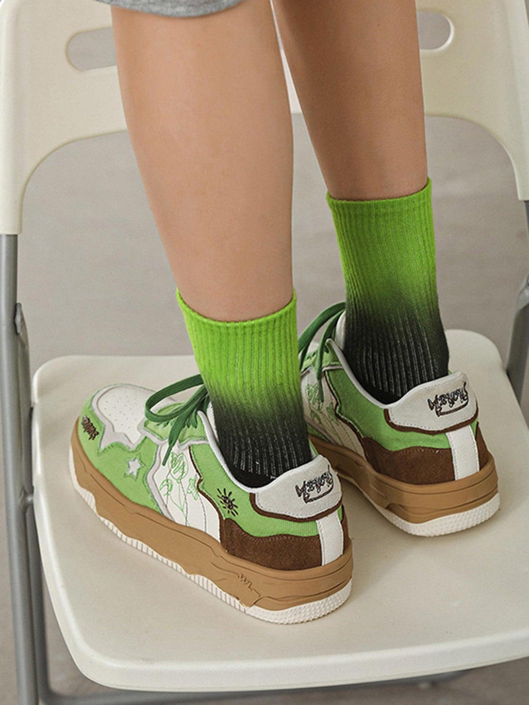 TALISHKO's green and brown board shoes with thick soles, paired with gradient socks, back view.