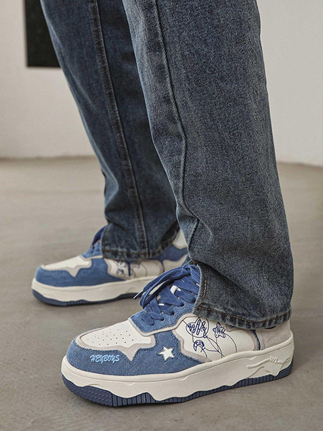 Casual sports shoes by TALISHKO with blue suede and star accents, styled with denim jeans.