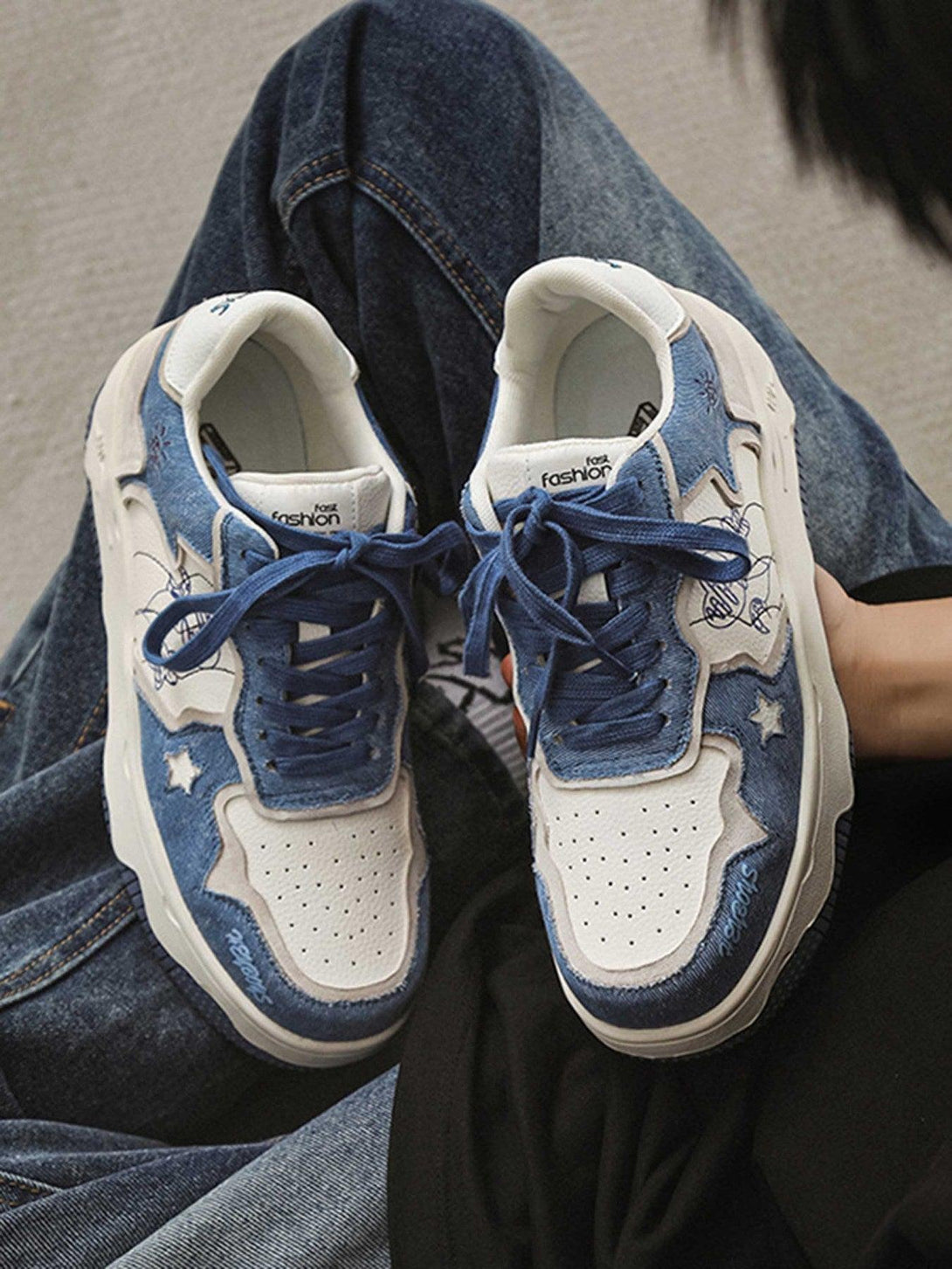 A close-up of TALISHKO's blue board shoes with star accents, paired with denim for a chic vibe.