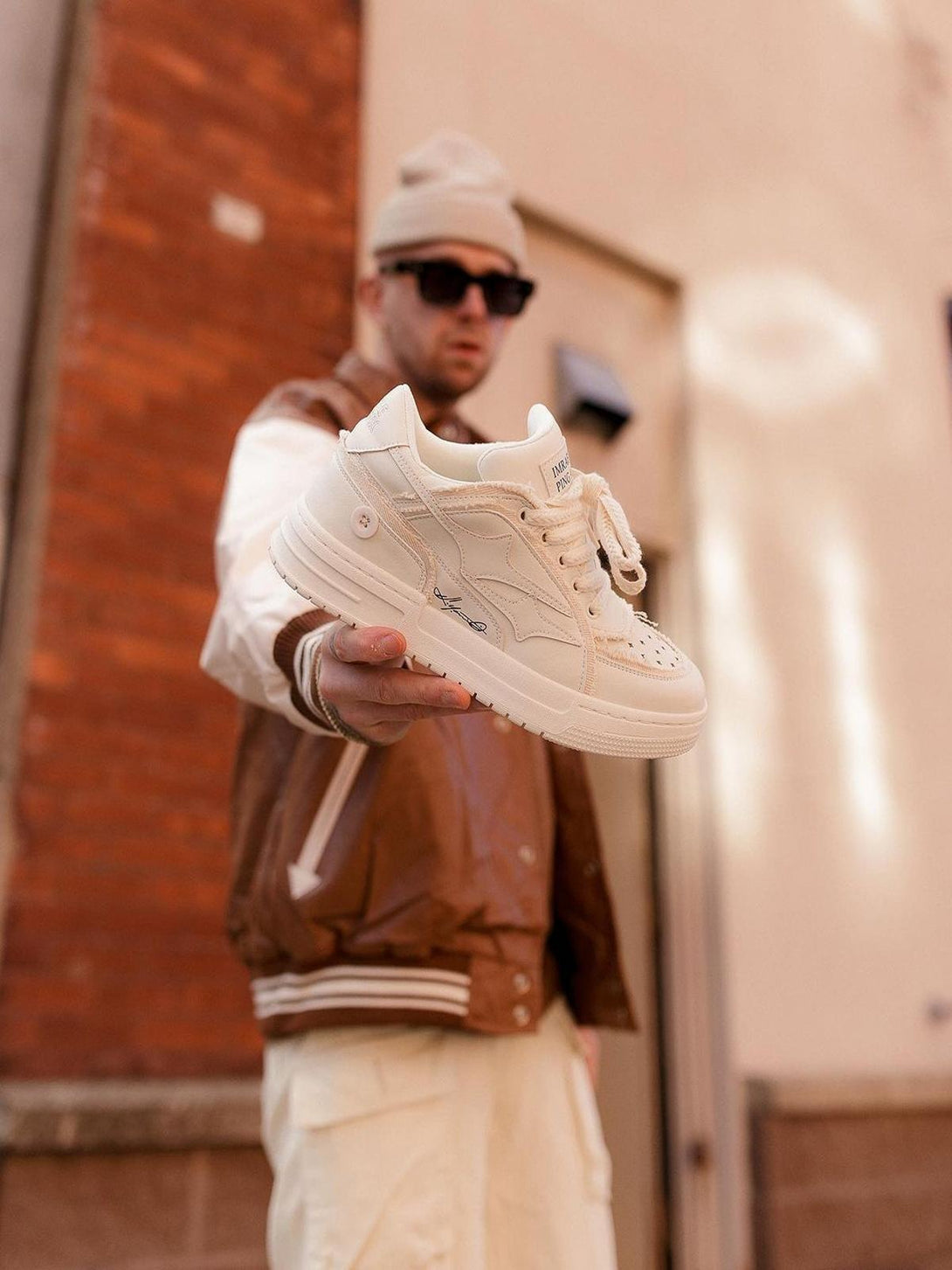 TALISHKO casual white board shoe held in hand, highlighting its sleek design and texture.